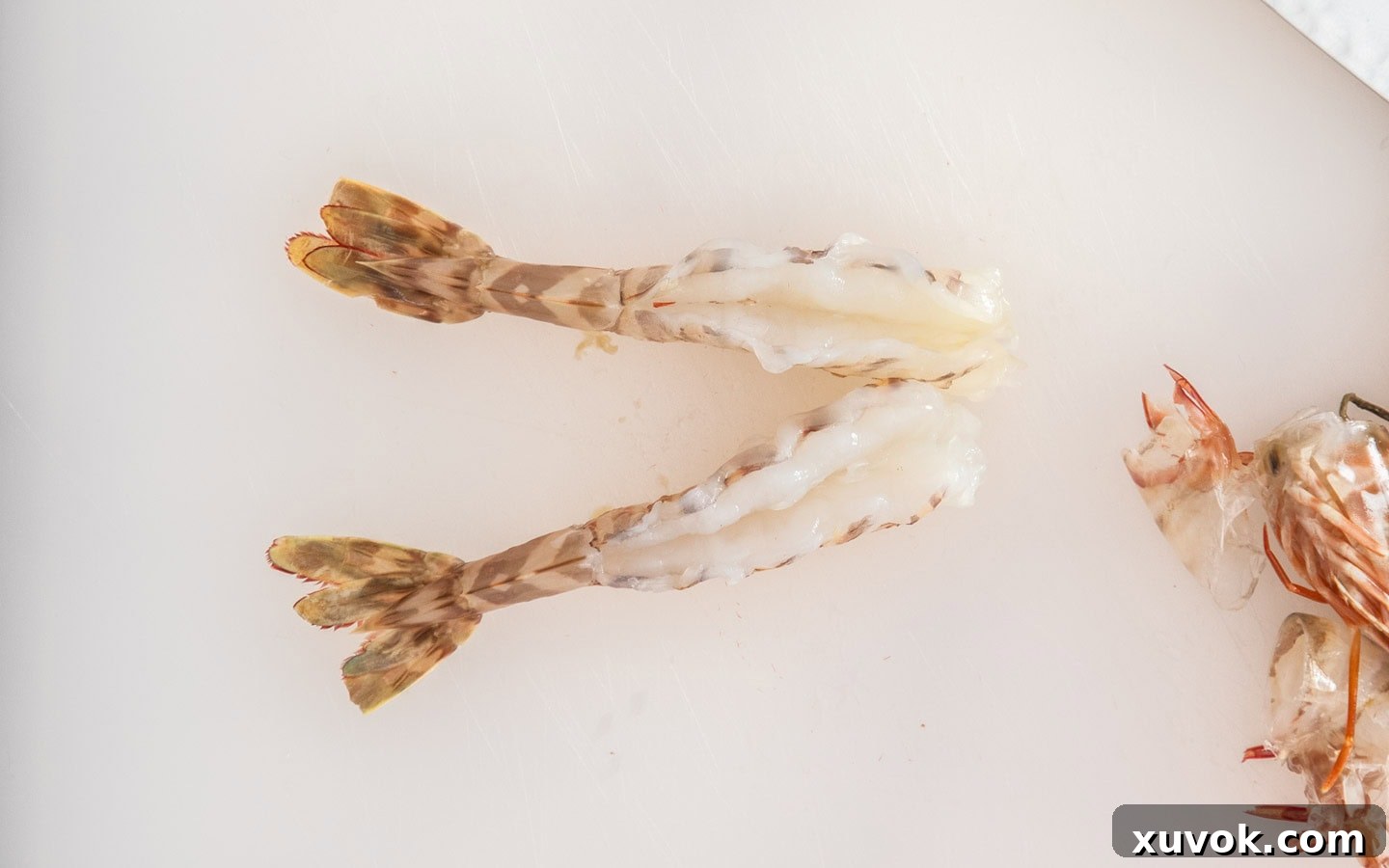 Top down view of two peeled and butterflied prawns, ready for seasoning.