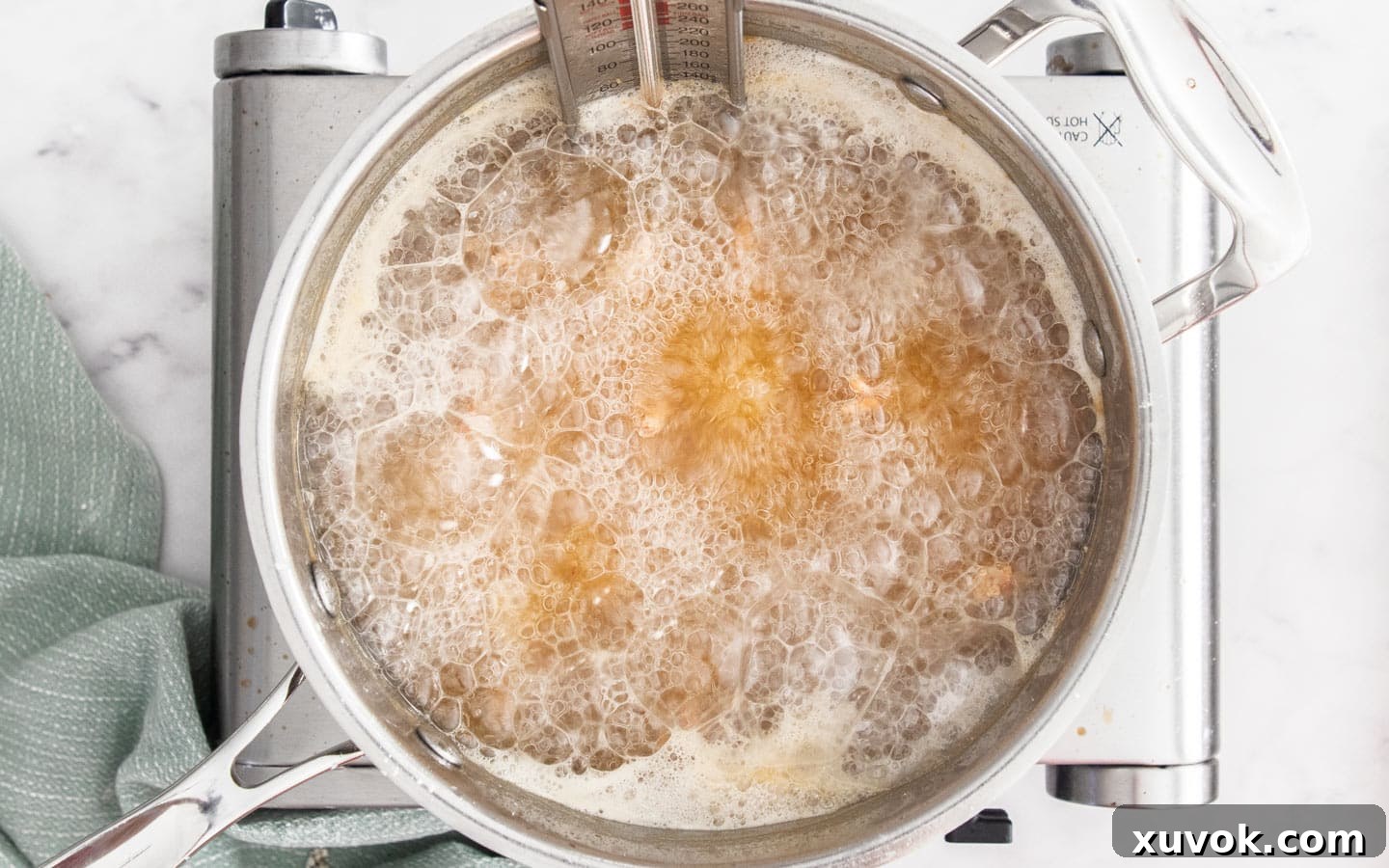 Prawns frying in hot oil during the second fry, showing active bubbling.