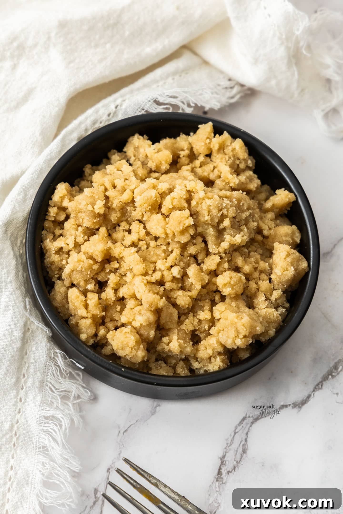 Unbaked streusel topping in a small black bowl.