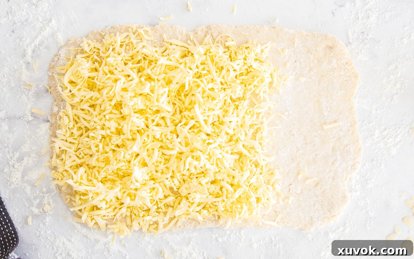 Grated cold butter evenly spread over two-thirds of the rolled-out Danish pastry dough.