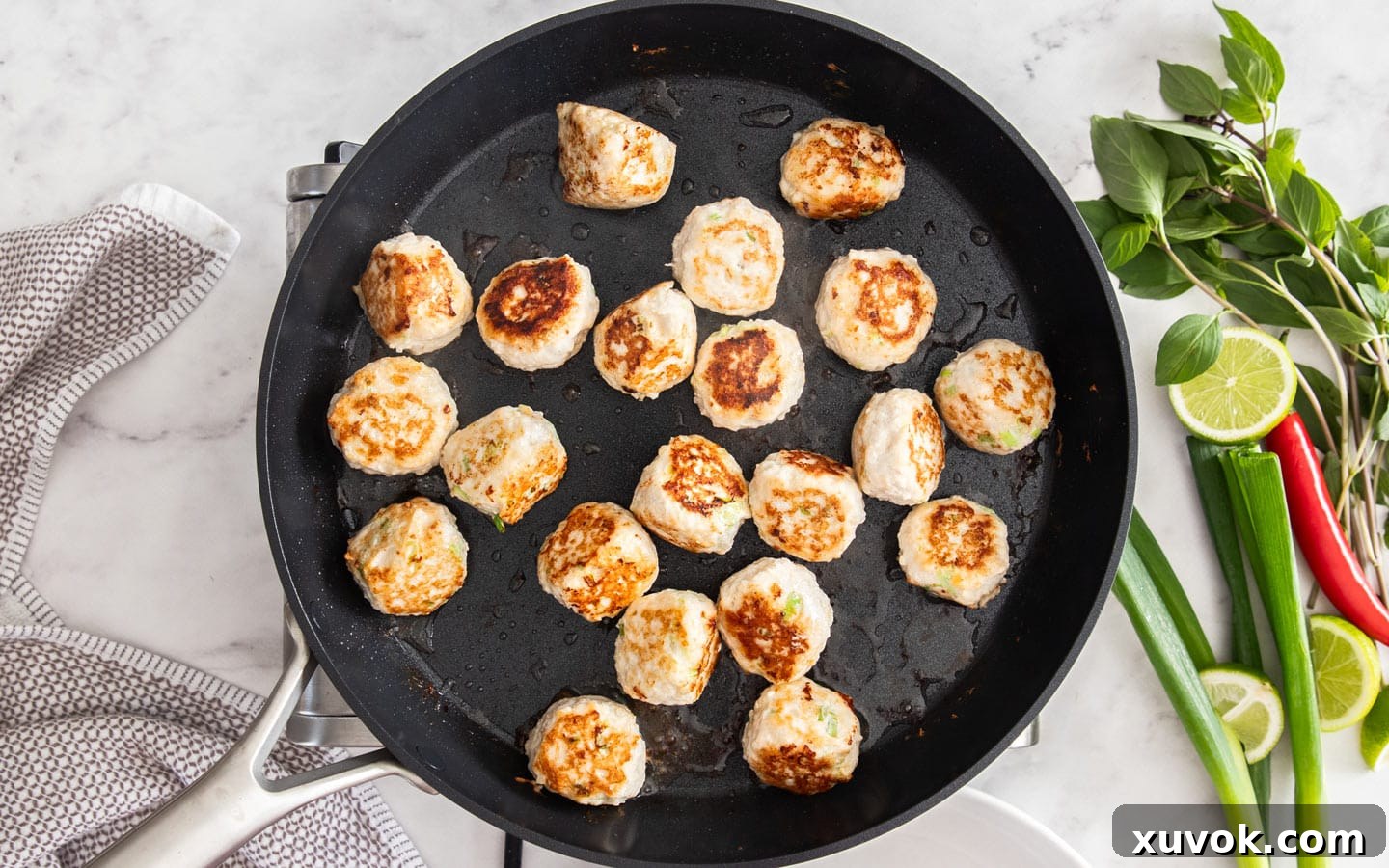 The curry chicken meatballs cooking in a pan.
