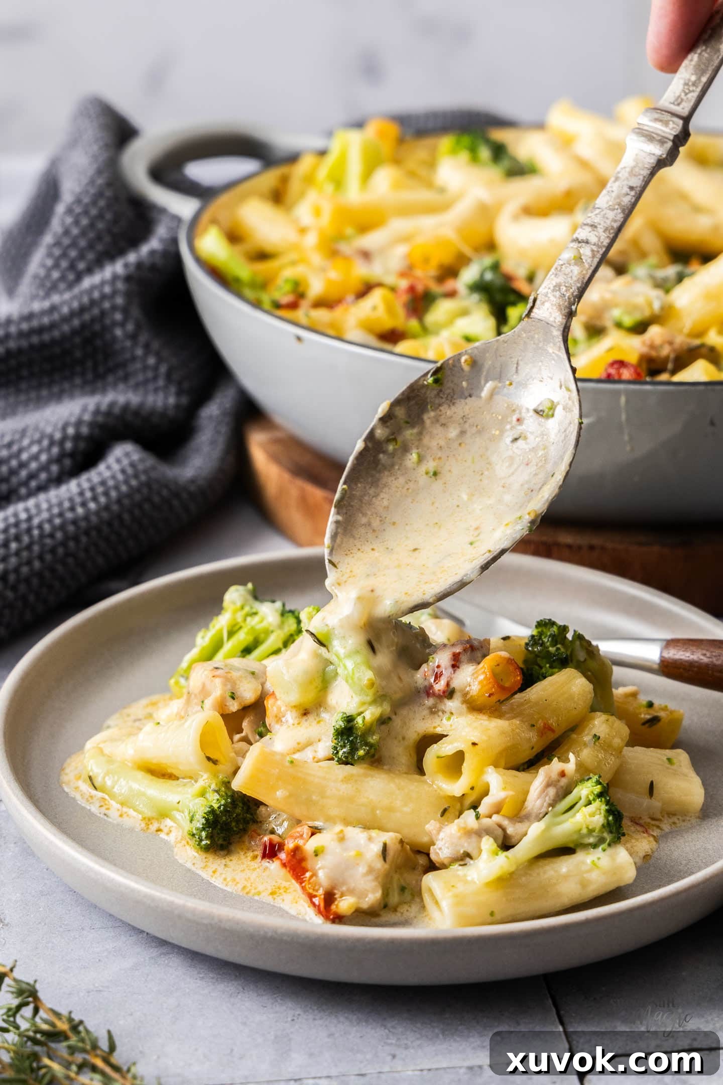 A serving spoon spooning some of the sauce over the pasta.