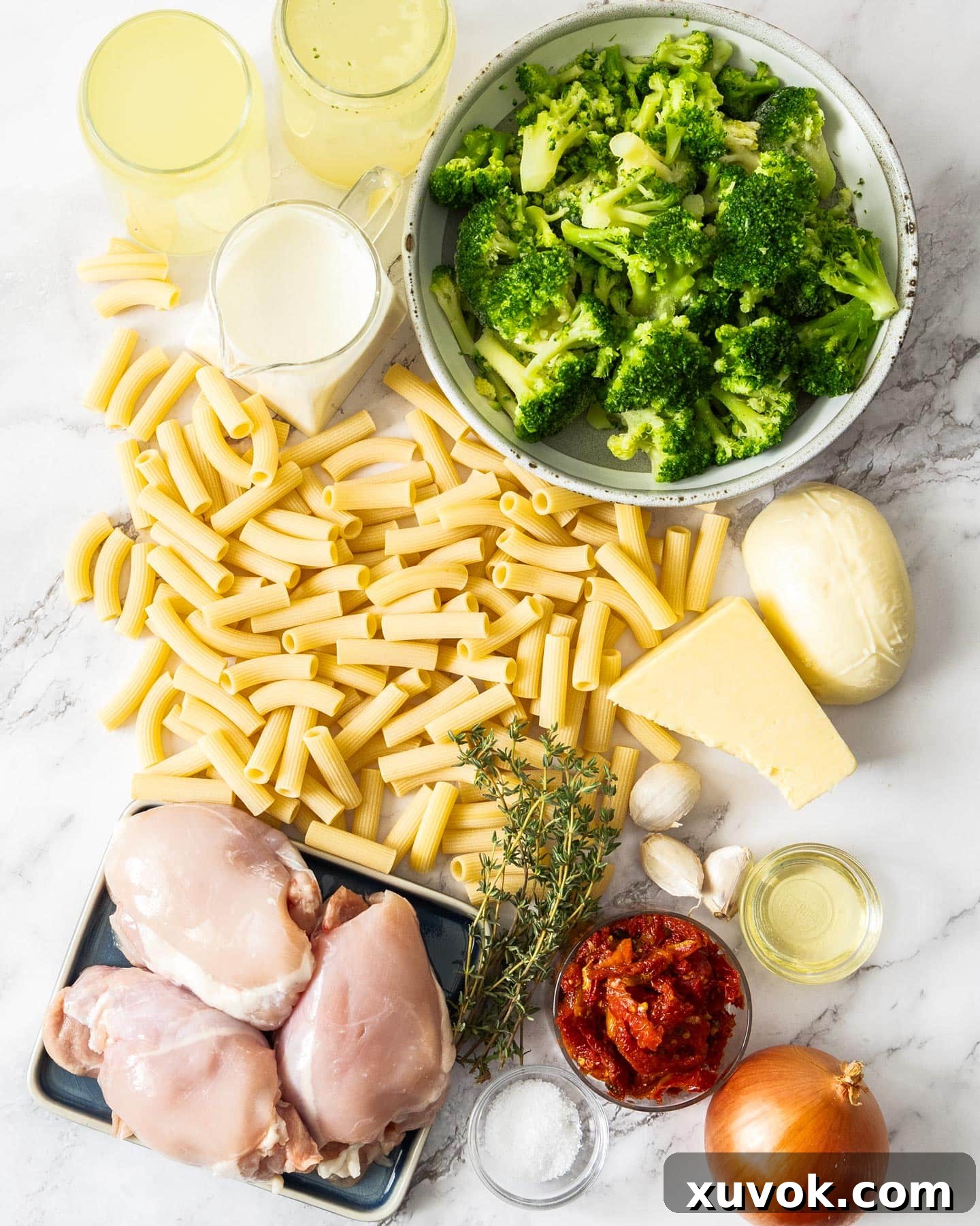 Ingredients for chicken and broccoli pasta bake on a marble surface.