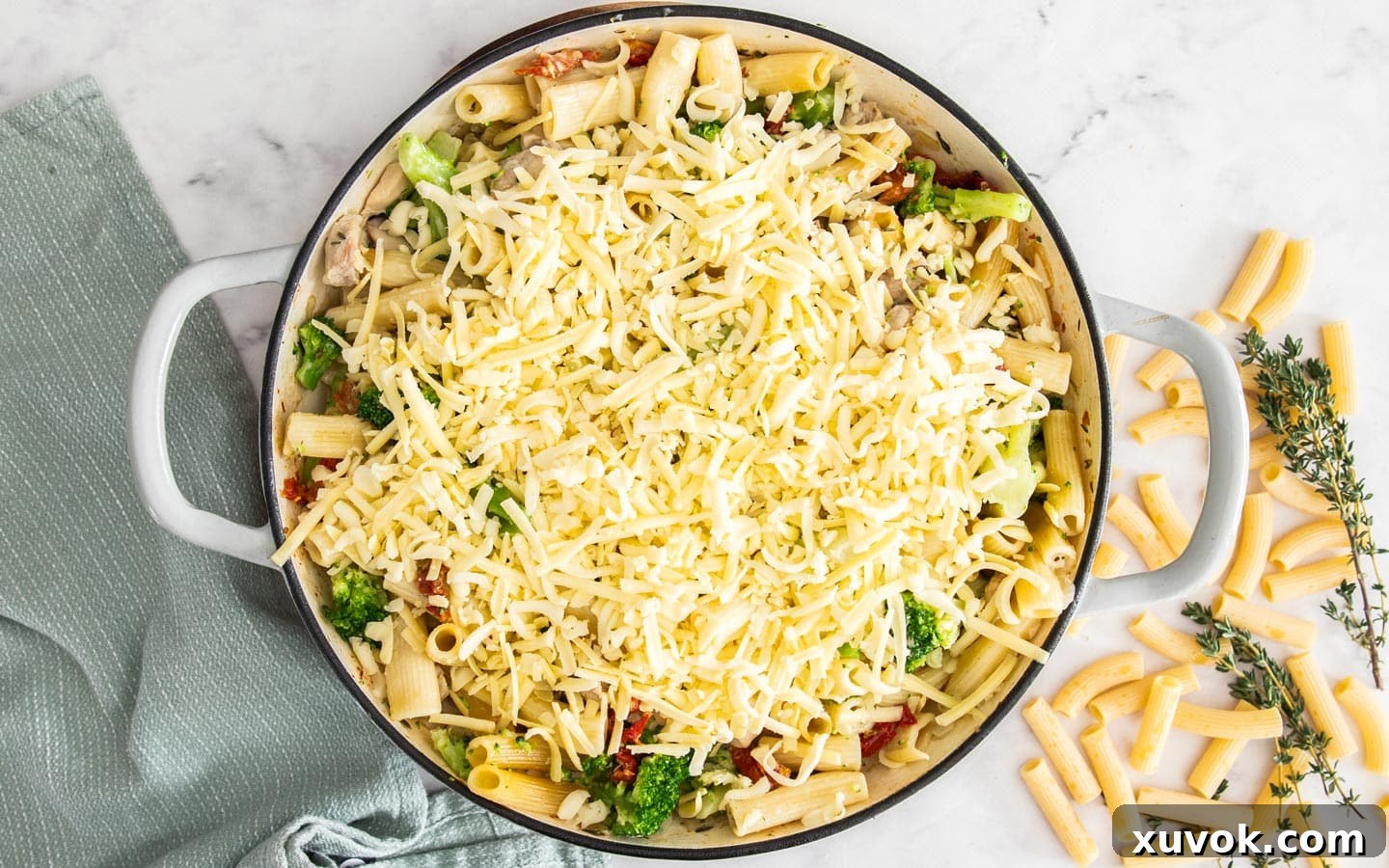 The pasta bake topped with cheese, ready to bake again.