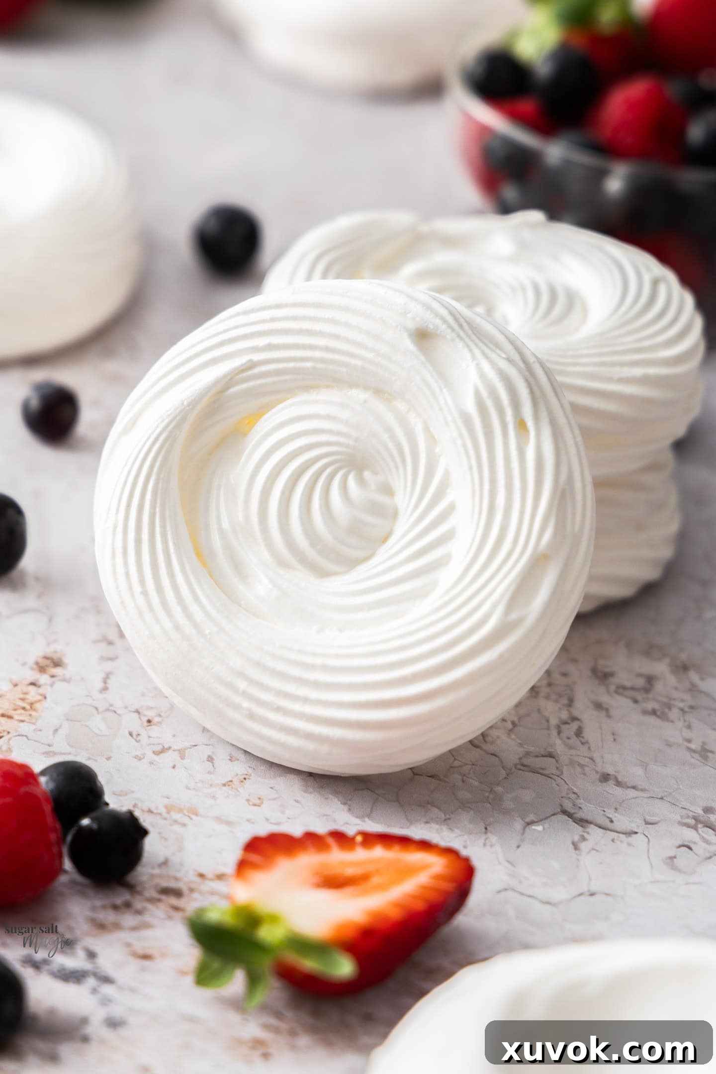 A meringue shell leaning up against a stack of other delicate meringue nests, showcasing their perfect shape and inviting texture.