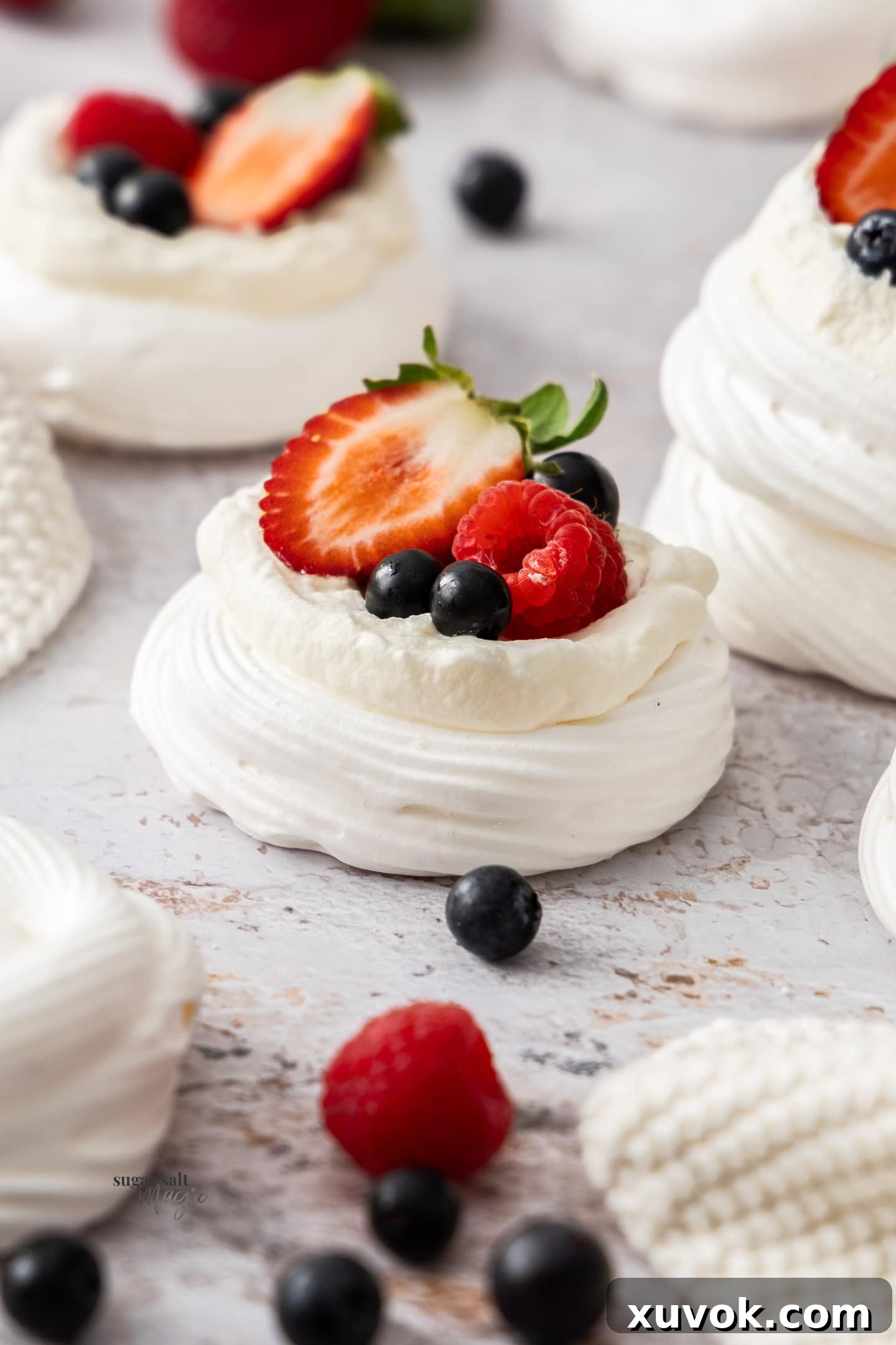 A beautifully garnished meringue nest filled with luscious cream and an assortment of fresh berries, ready to be enjoyed.