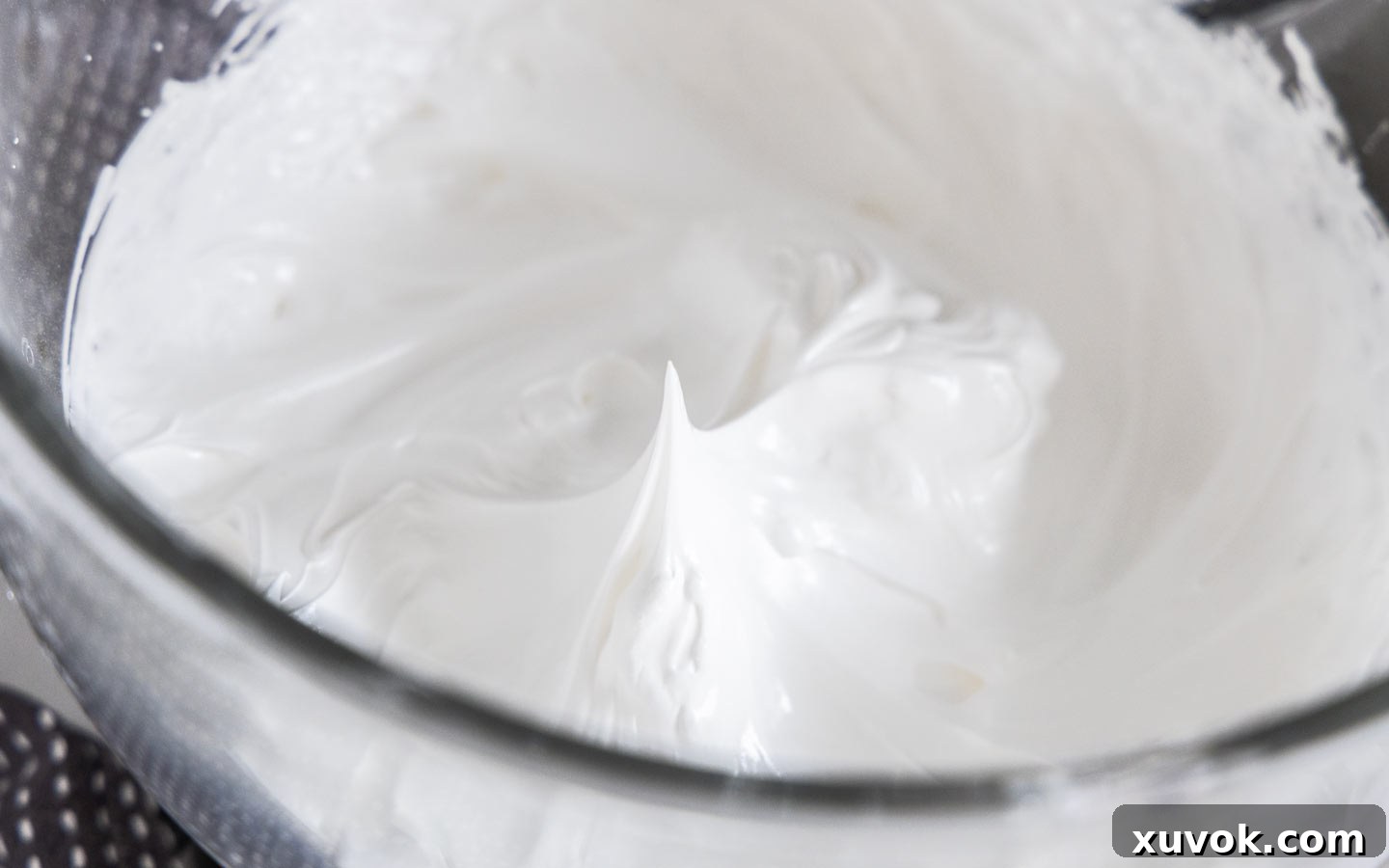 The meringue mixture in a bowl, having reached the ideal stiff peak stage.
