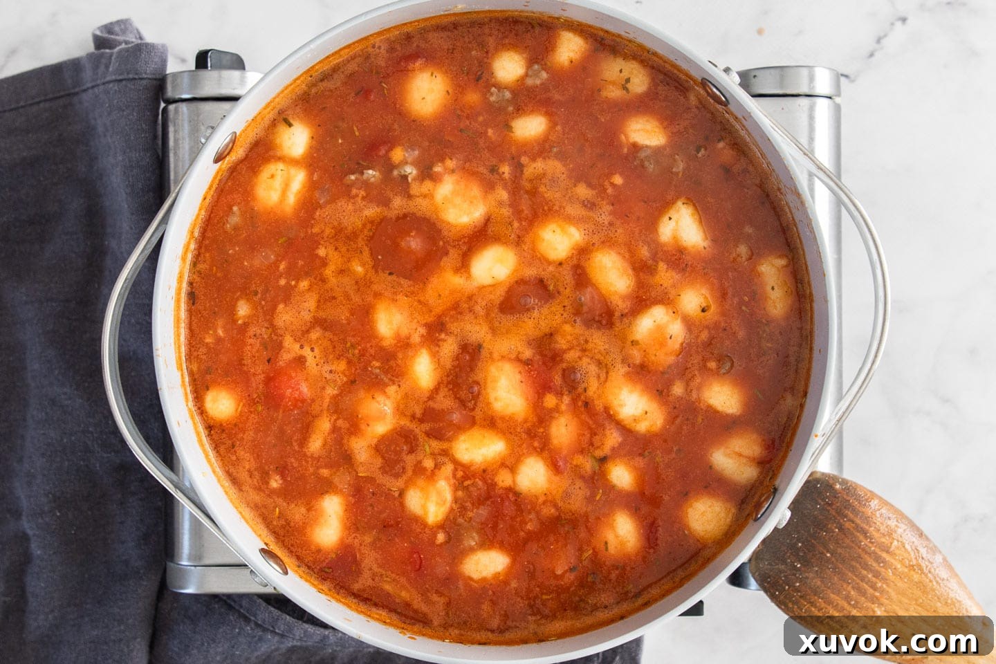Tender potato gnocchi swimming in the rich sausage and tomato soup, absorbing all the delicious flavors as they cook.