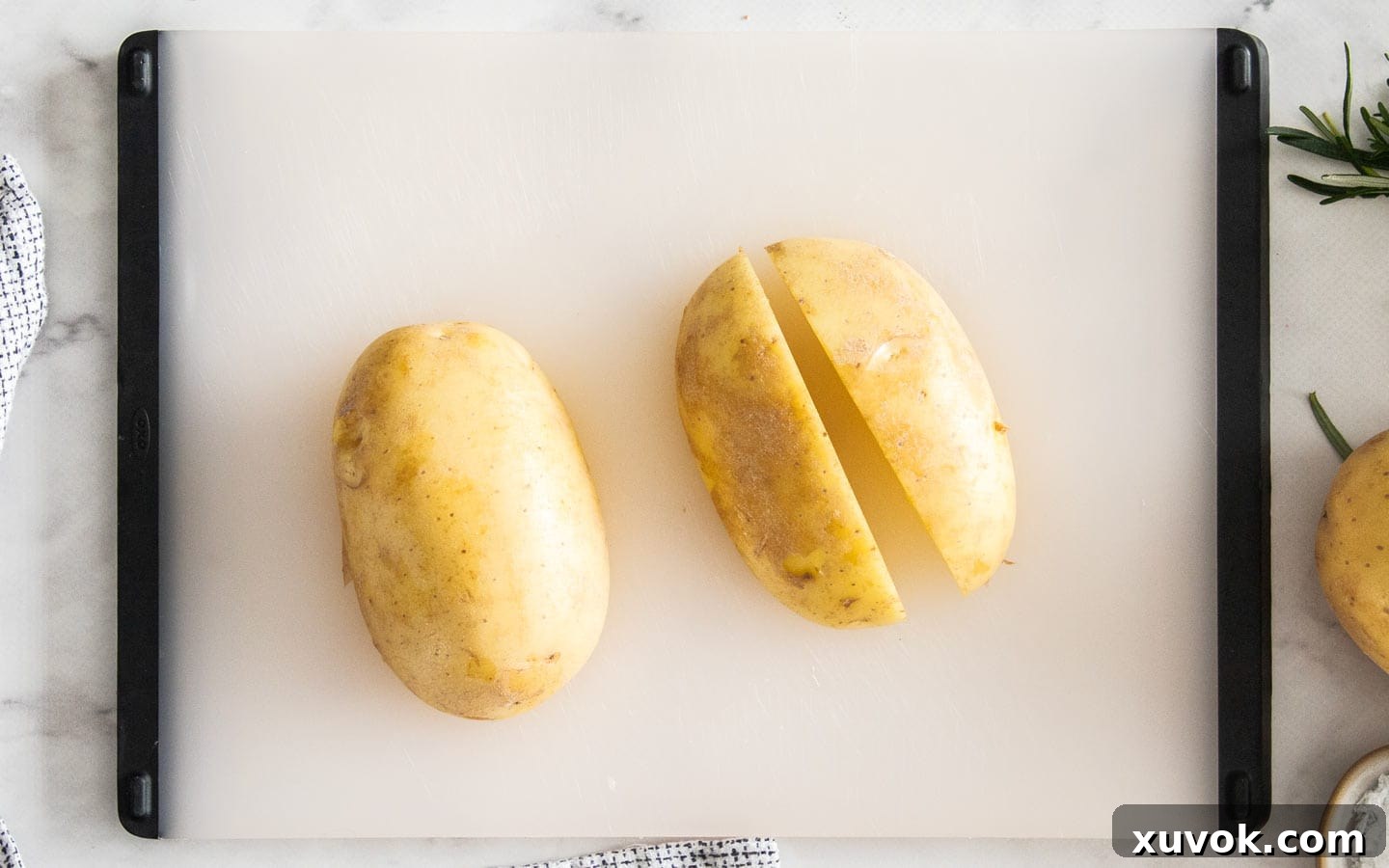A potato cut in half, with one half further quartered, demonstrating the initial slicing steps.