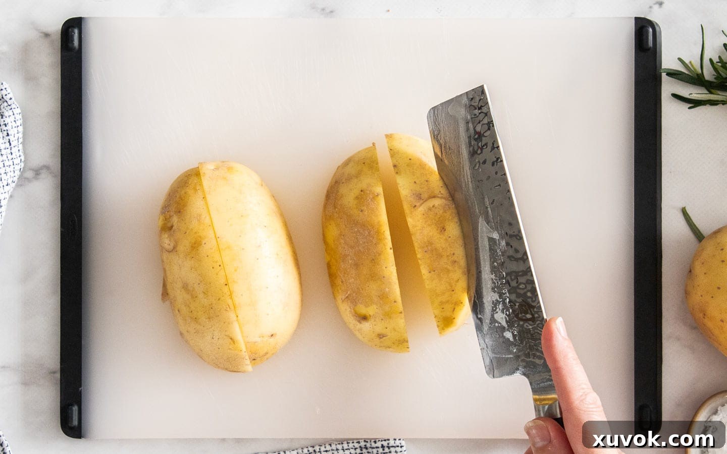 A knife demonstrating the diagonal cut to form potato wedges from a quartered potato.