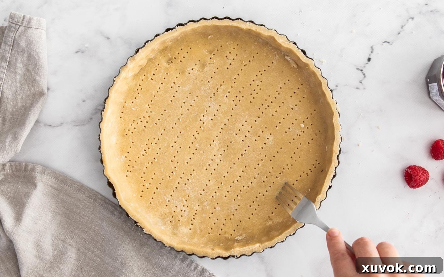 A fork poking holes in the base of the pastry crust.