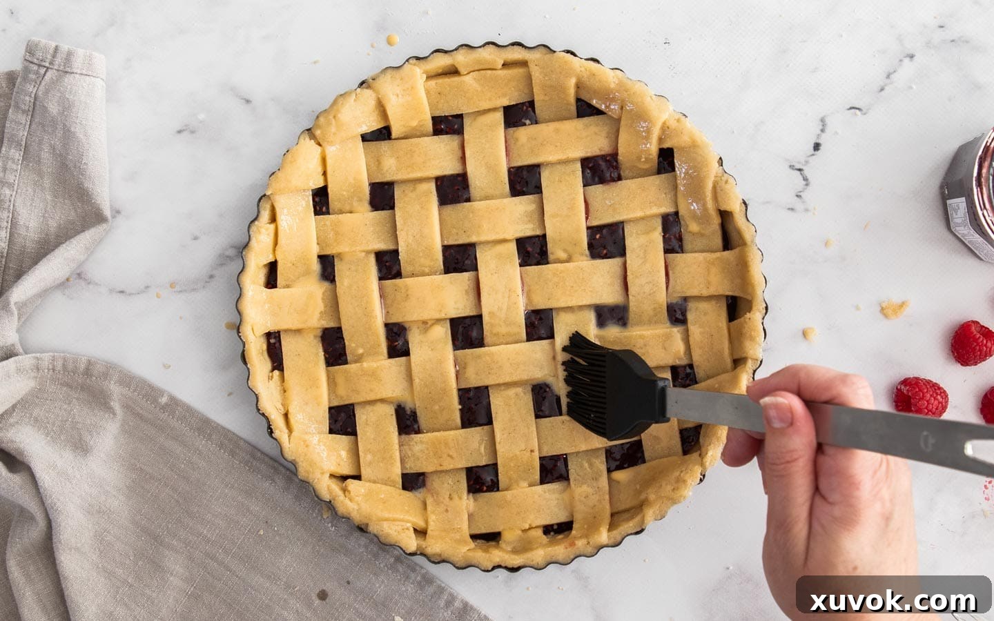 Brushing the tart with egg wash.