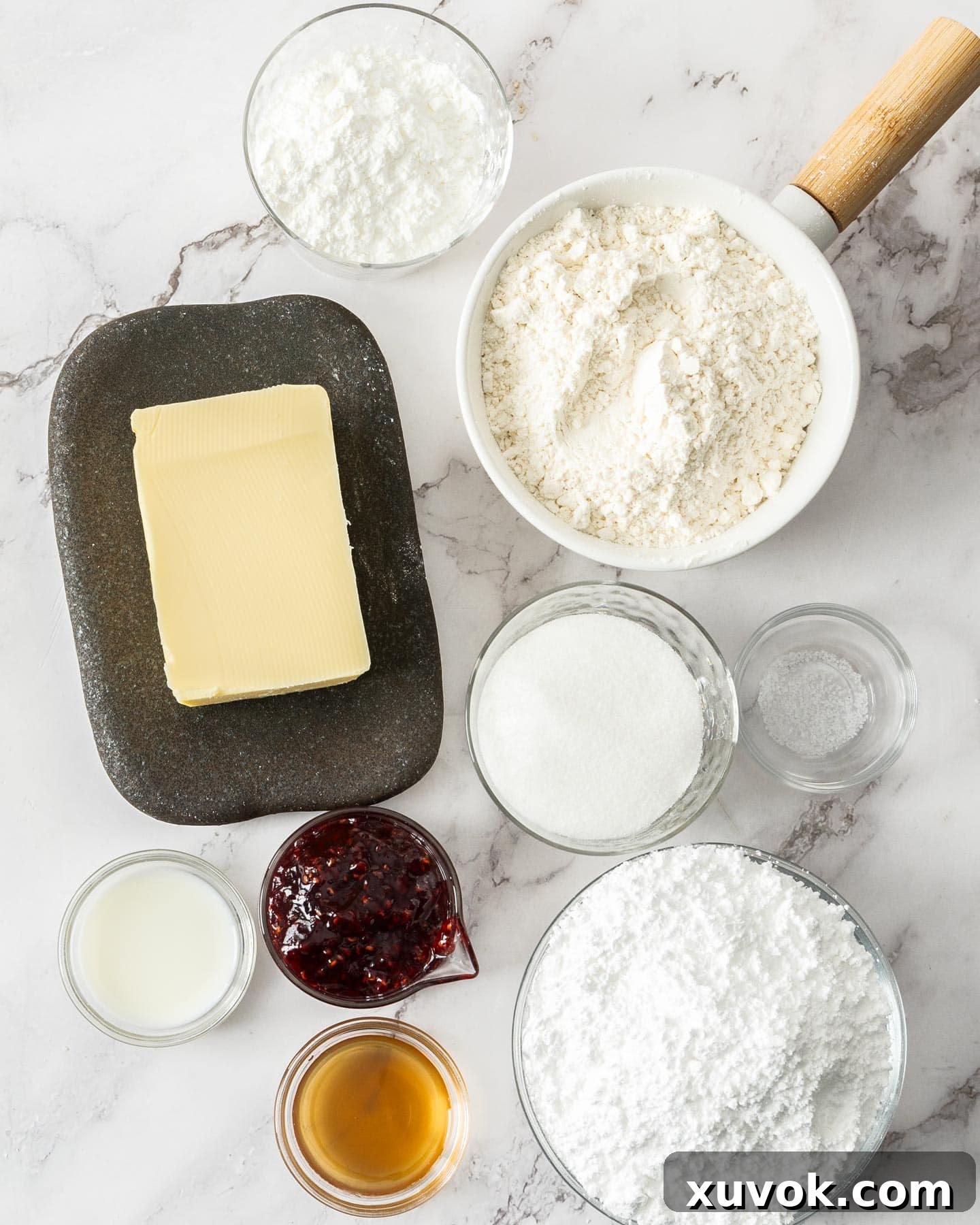 Ingredients for Viennese whirls laid out on a table, including butter, flour, sugar, and jam.