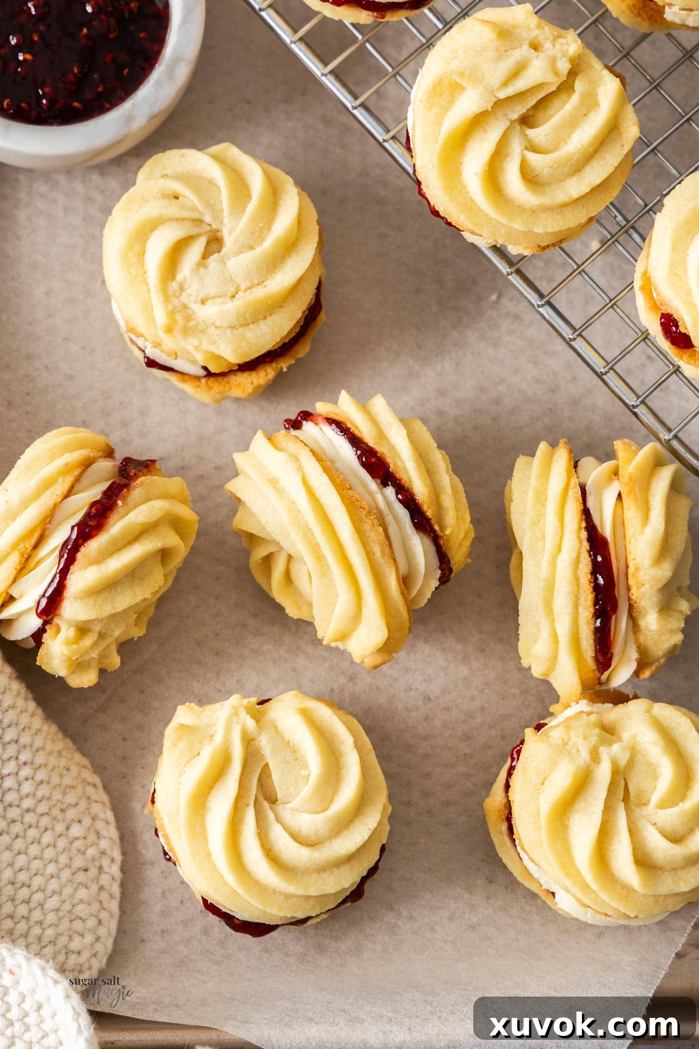 Top down view of a batch of freshly baked Viennese whirl biscuits arranged neatly.