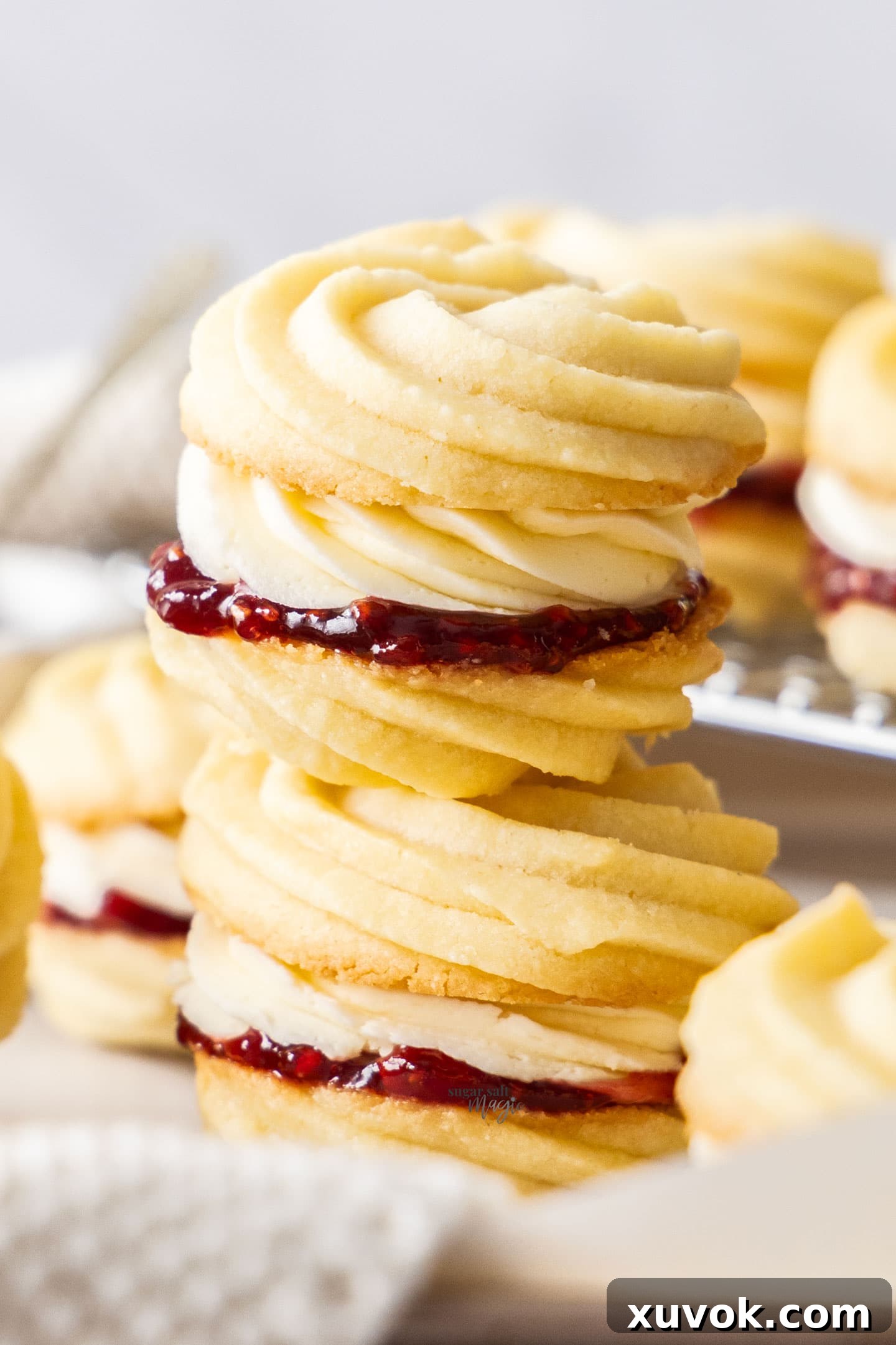 Two Viennese whirls stacked on top of each other, showing the jam and buttercream filling.