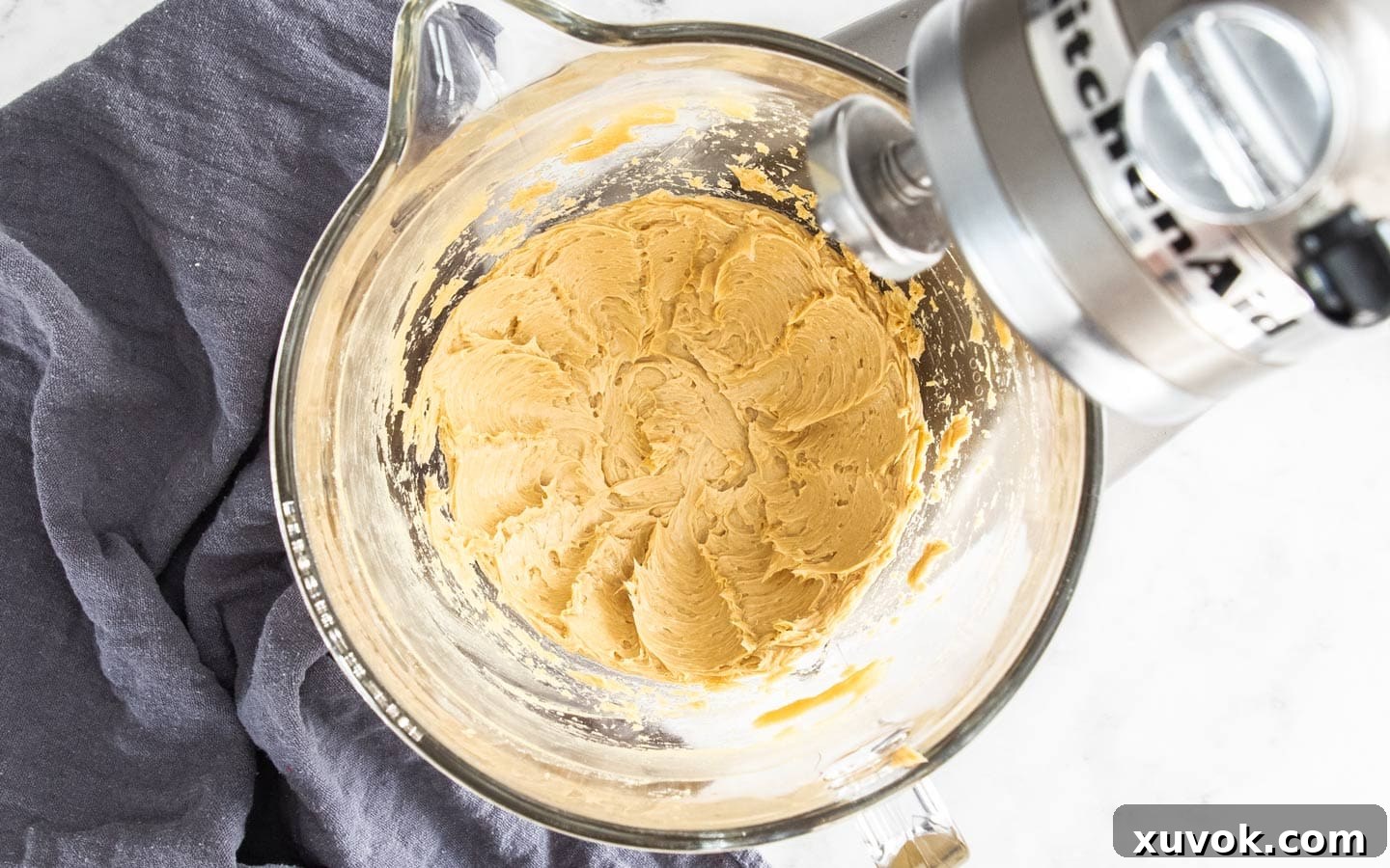 Softened butter and brown sugar creaming together in a stand mixer bowl, forming a light and fluffy base for the buttercream.