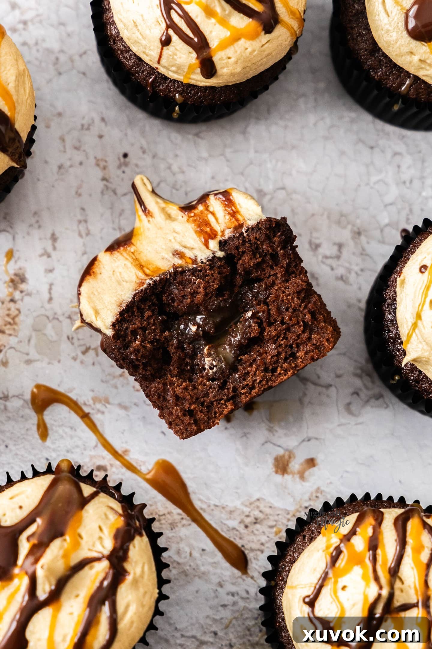 Top-down view of a chocolate caramel cupcake, expertly cut in half to showcase the irresistible oozy caramel filling nestled within its dark, moist crumb.