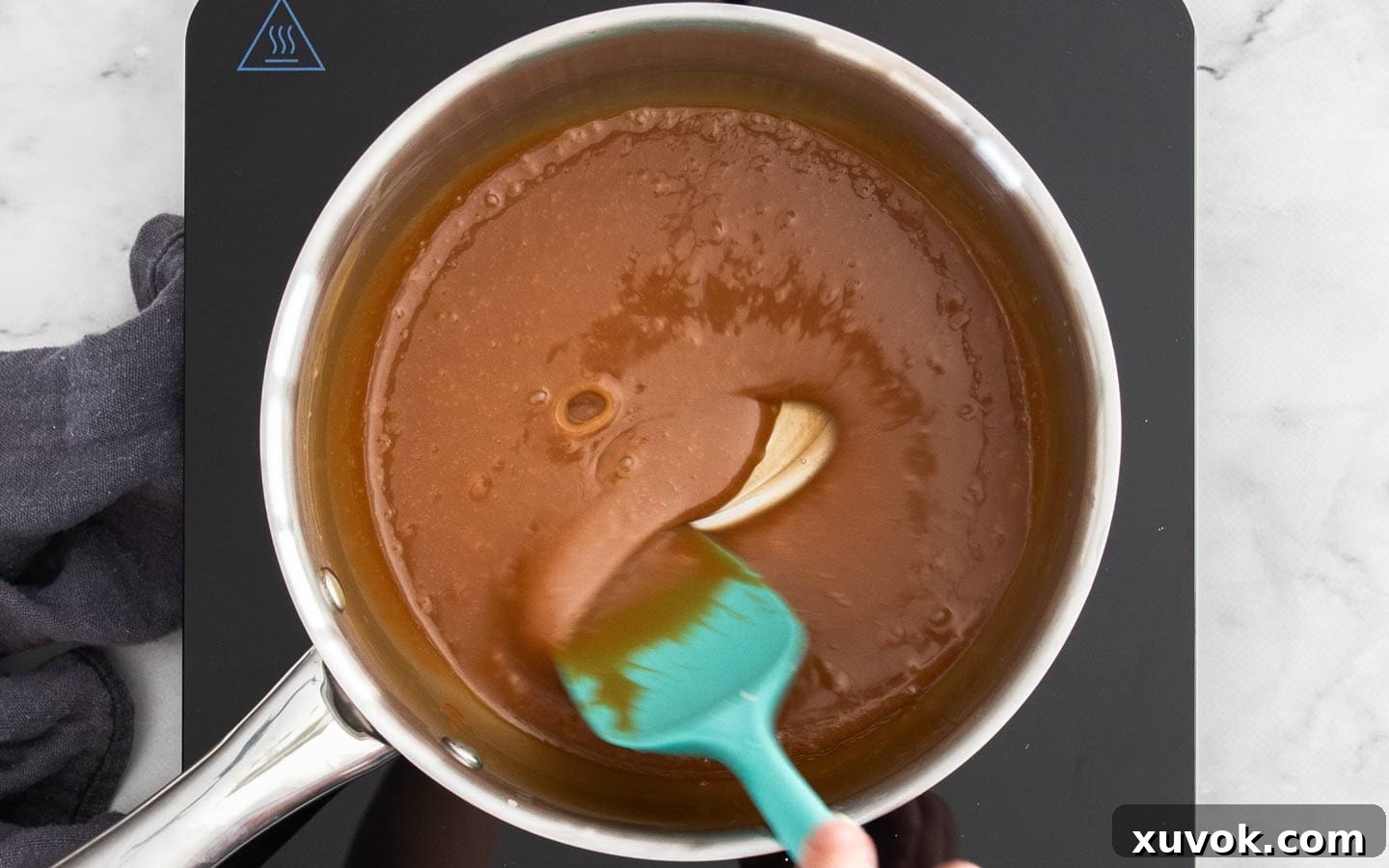 The caramel sauce in a saucepan, now smooth and perfectly combined after melting the caramels with cream.
