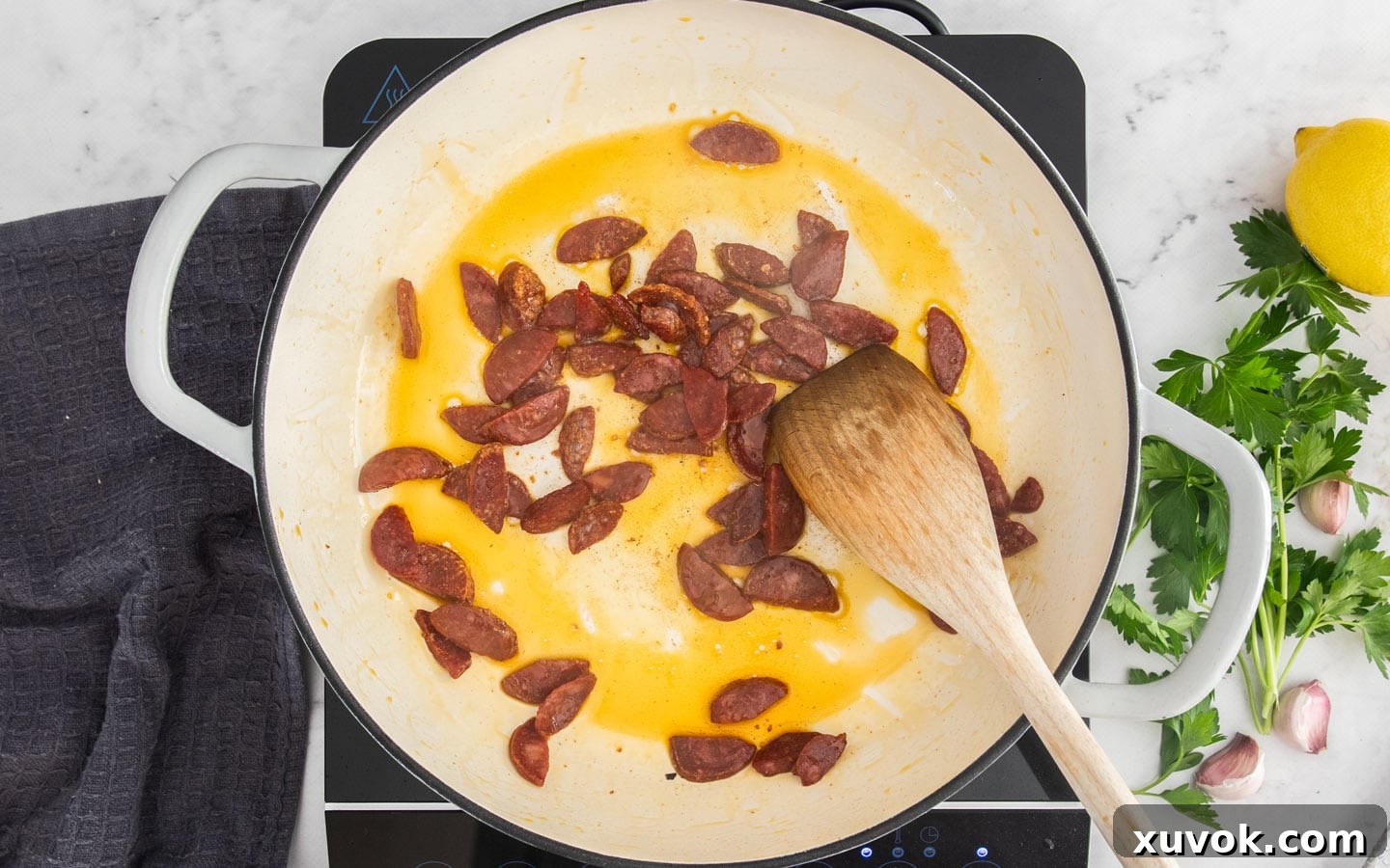 The chorizo cooking in the pan.