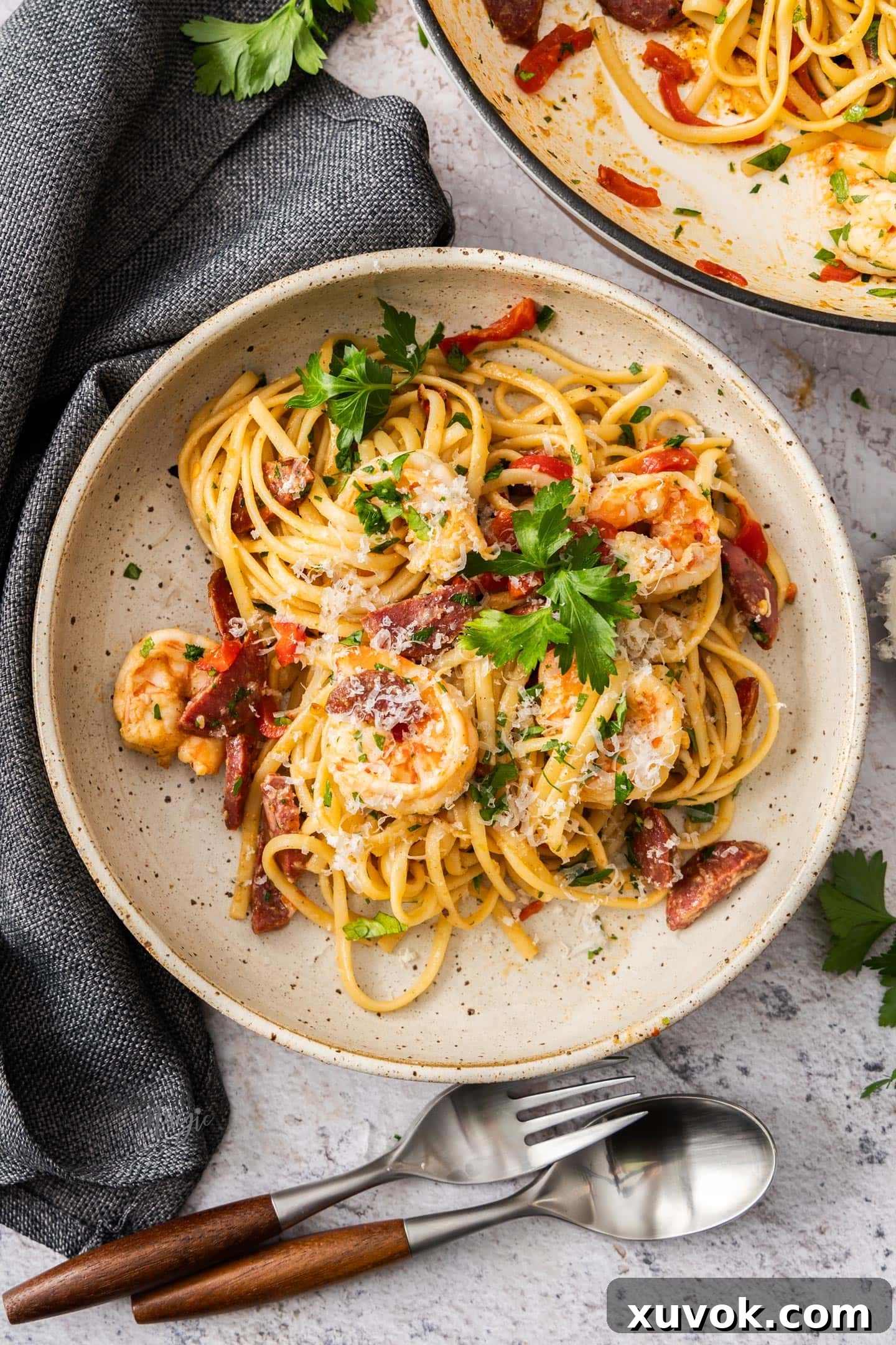 Top down view of a serve of prawn and chorizo linguine in a pasta bowl.