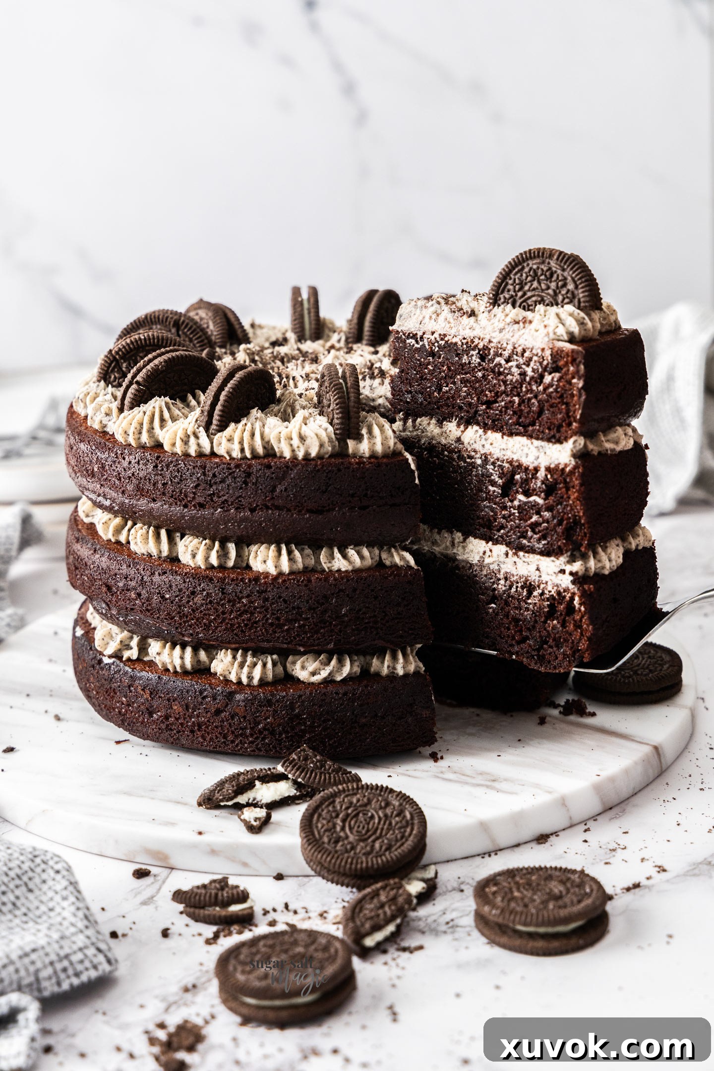 An Oreo chocolate cake with a large slice being taken out.