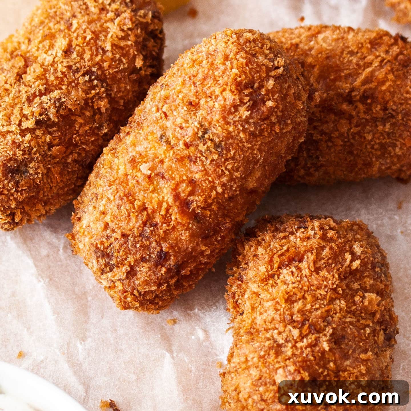 A close-up view of the perfectly golden and crispy exterior of homemade pork croquettes, inviting a delicious bite.