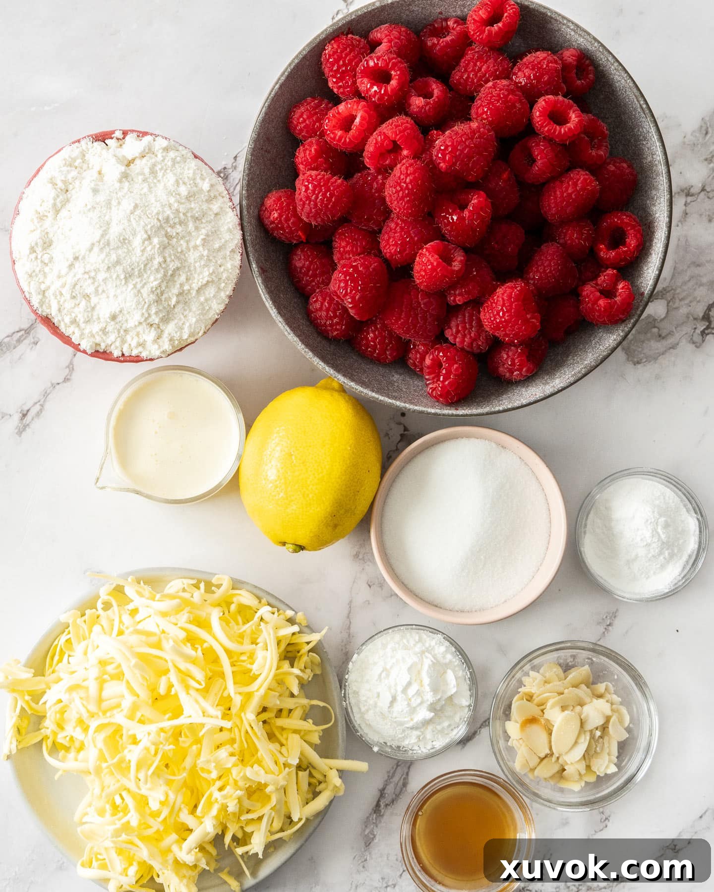 Ingredients for raspberry cobbler on a marble surface.