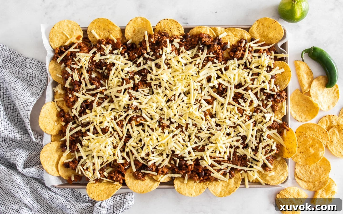 The assembled nachos, generously topped with cheese, waiting to be baked to golden perfection.