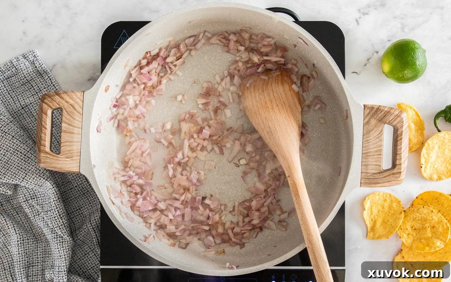 Diced onions cooking in a hot pan, becoming translucent.