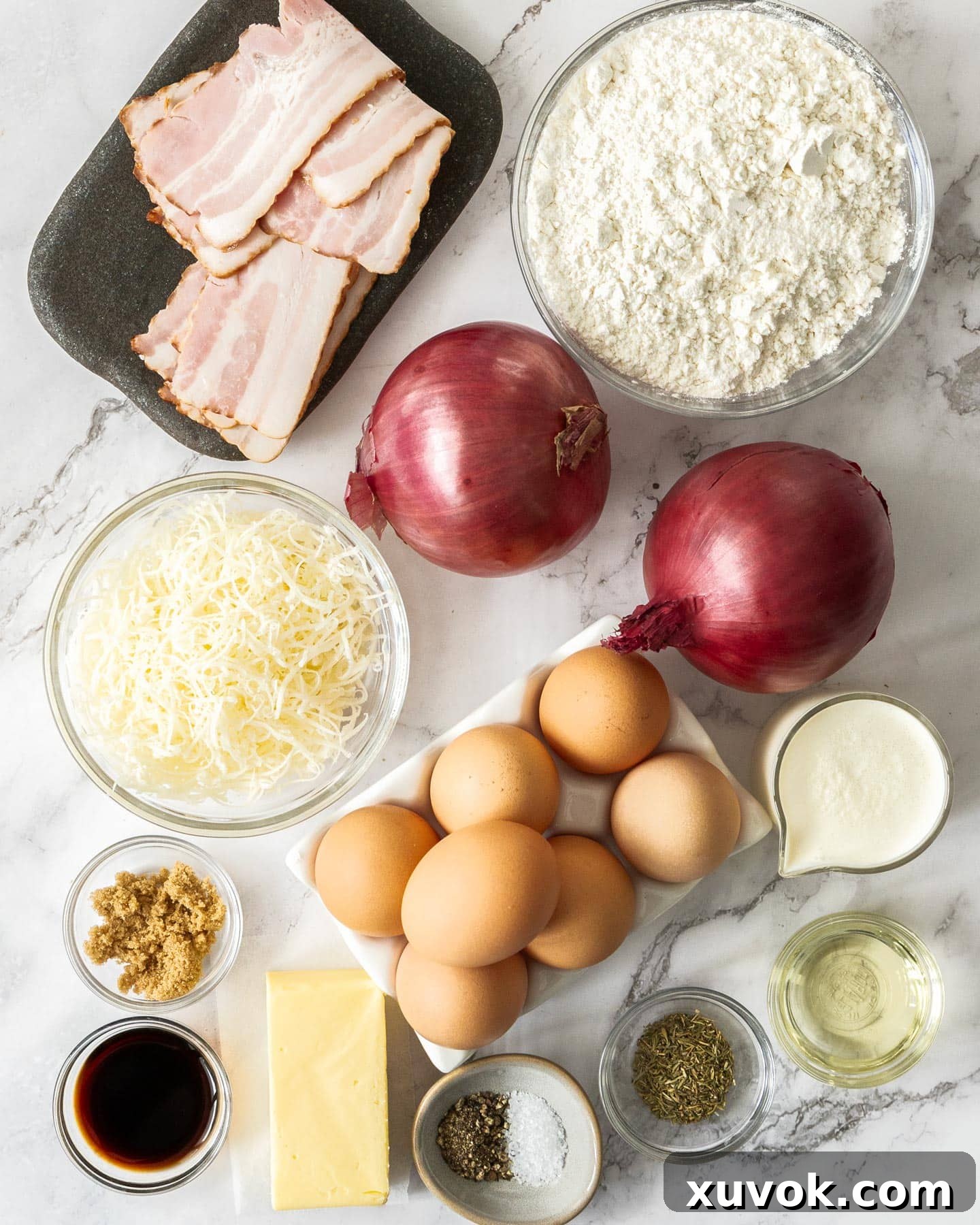 A vibrant selection of fresh ingredients laid out on a wooden surface, including red onions, bacon, eggs, cheese, flour, and butter, all prepared for making a delicious Bacon and Caramelised Onion Quiche.