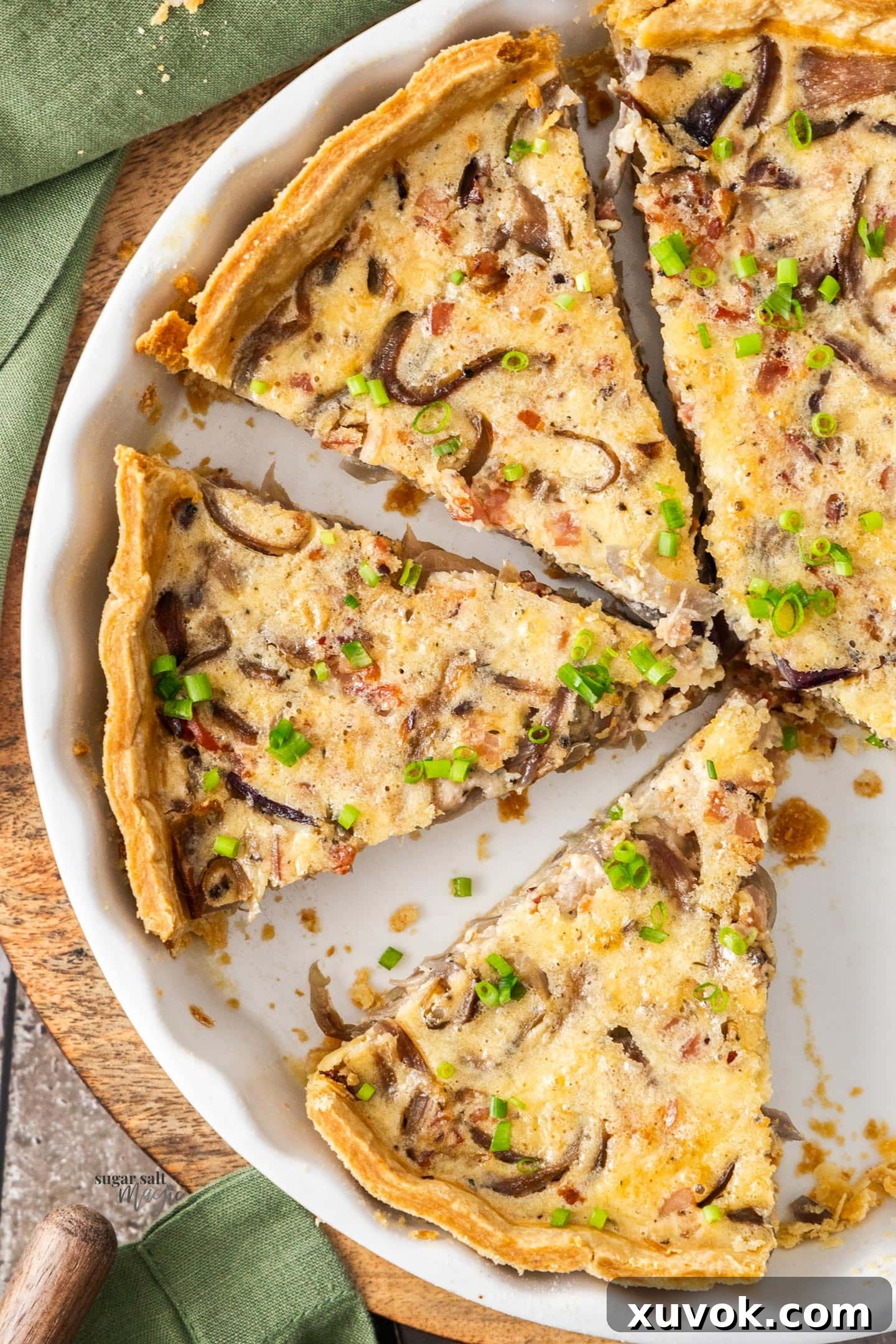 A beautifully sliced Bacon and Caramelised Onion Quiche, revealing its golden crust, layers of sweet onions and savory bacon, and creamy egg filling. Ready to be served for a delightful meal.