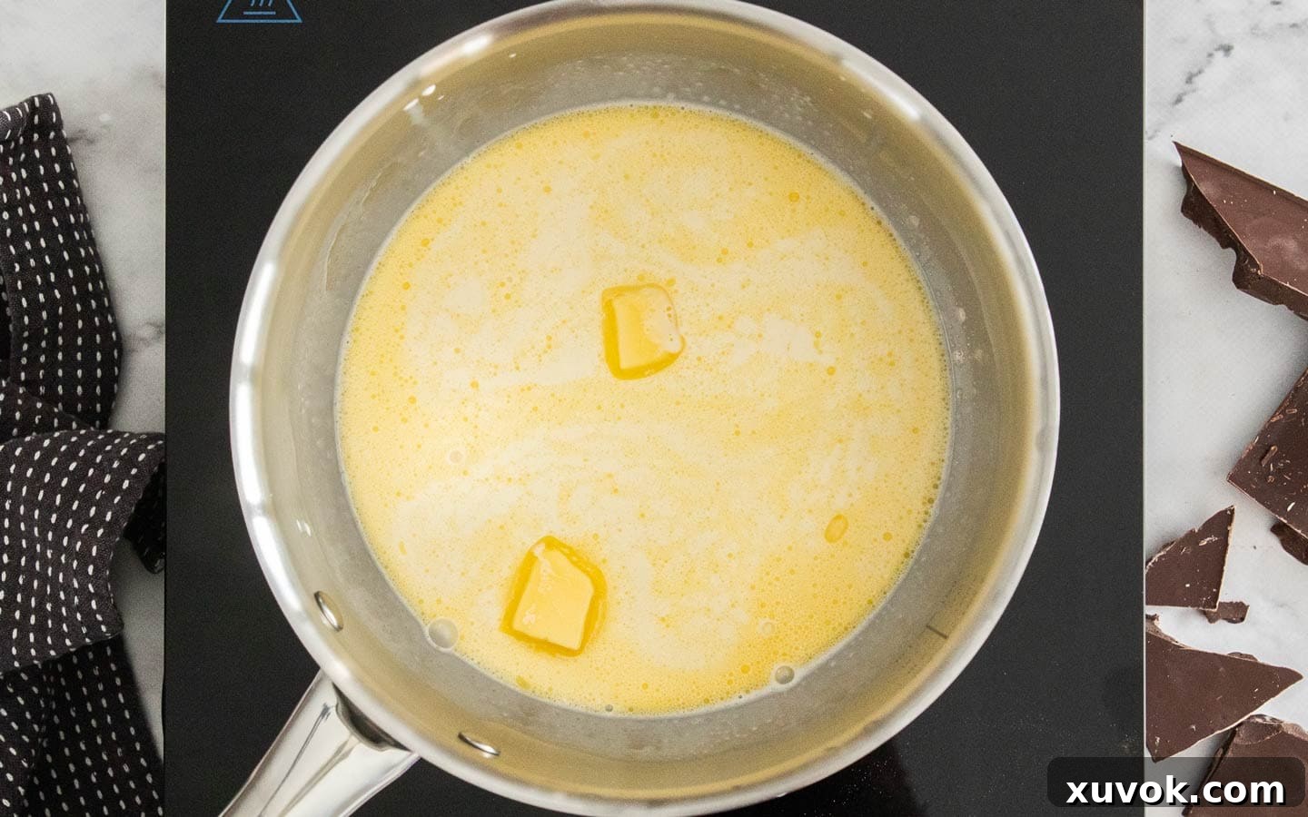 Butter melting into cream in a pan.