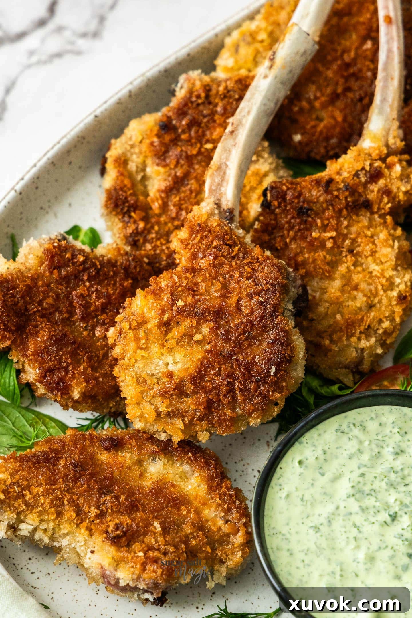 Closeup of crumbed lamb cutlets on a platter, perfectly golden and crunchy.
