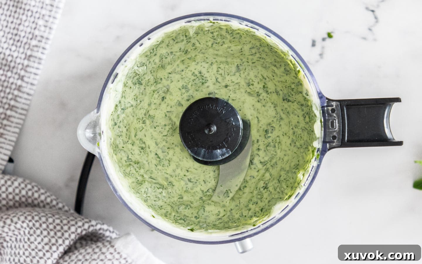 The finished mint mayonnaise mixture in a mini food chopper, showcasing its smooth, creamy texture and vibrant green color.