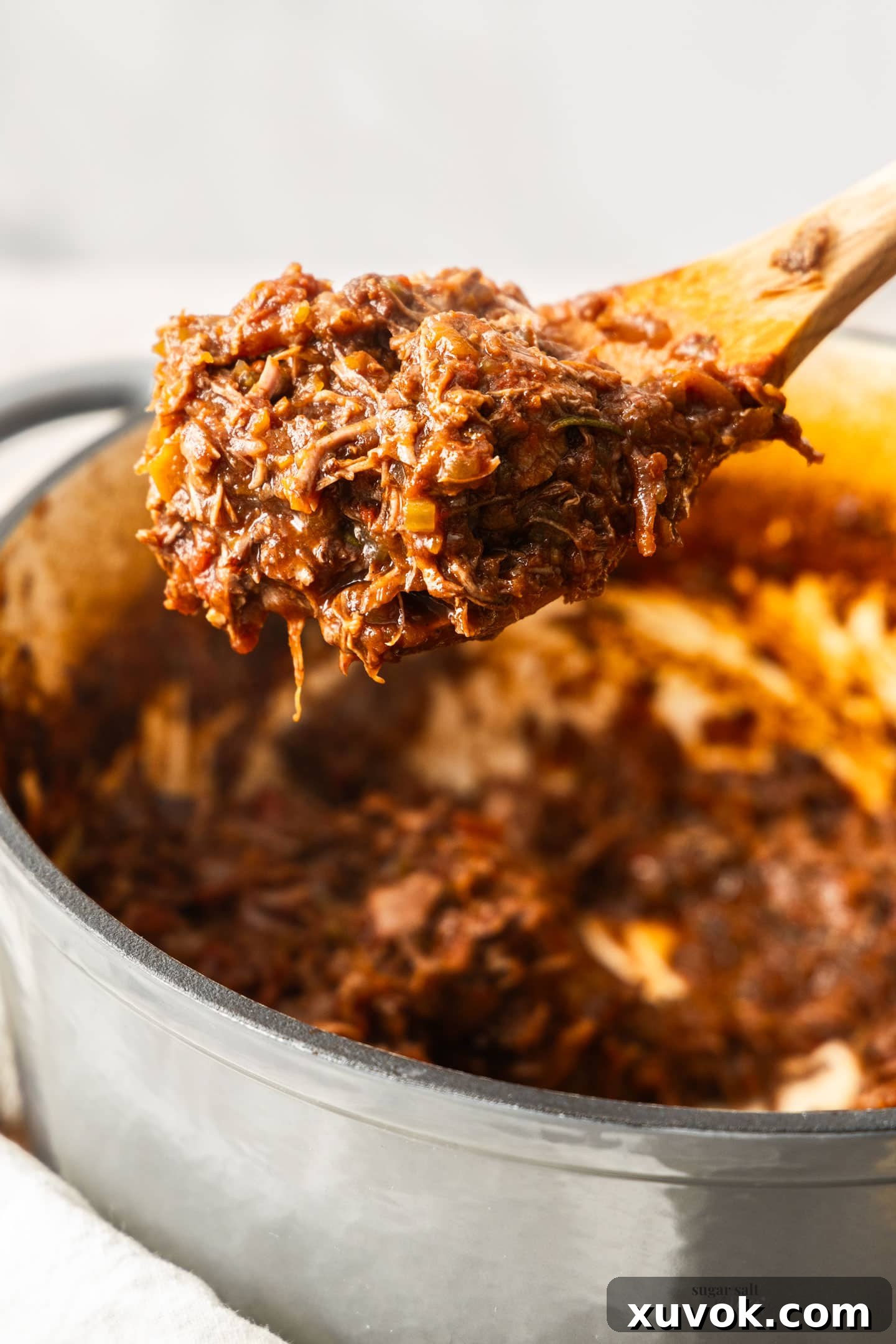 Beef shin ragu on a wooden spoon.