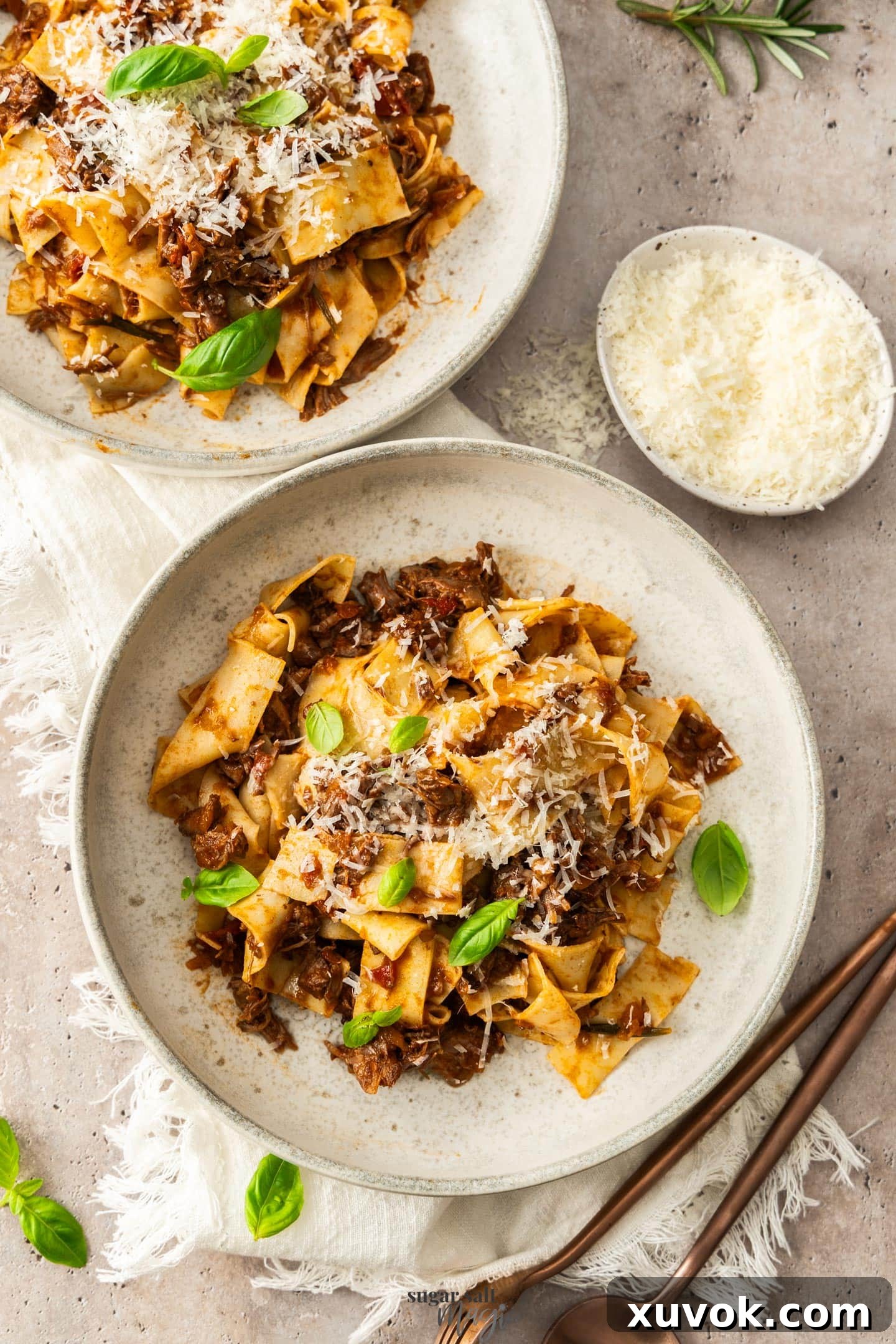 Top down view of 2 dinner bowls filled with beef shin ragu pasta.
