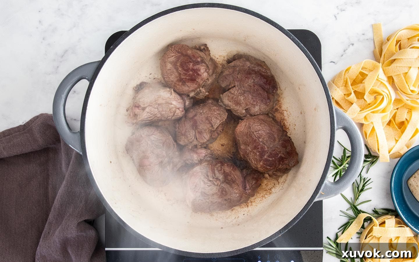 Pieces of beef shin browning in a pan.