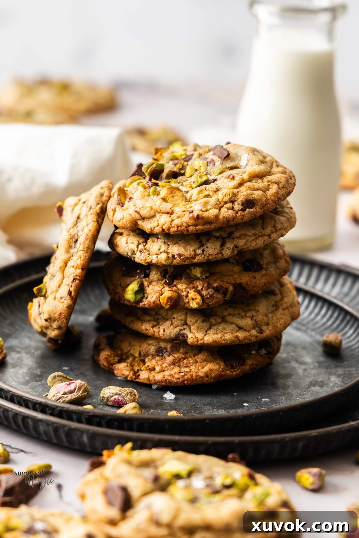 A stack of chocolate chip pistachio cookies on a metal tray.