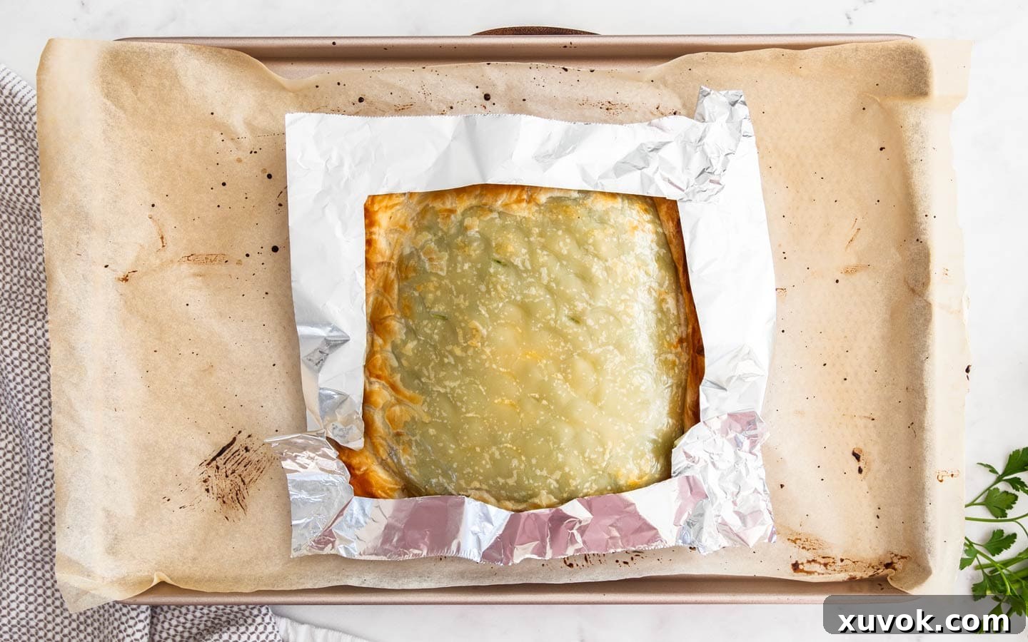 The salmon en croute with aluminium foil covering the edges to stop them burning during baking.