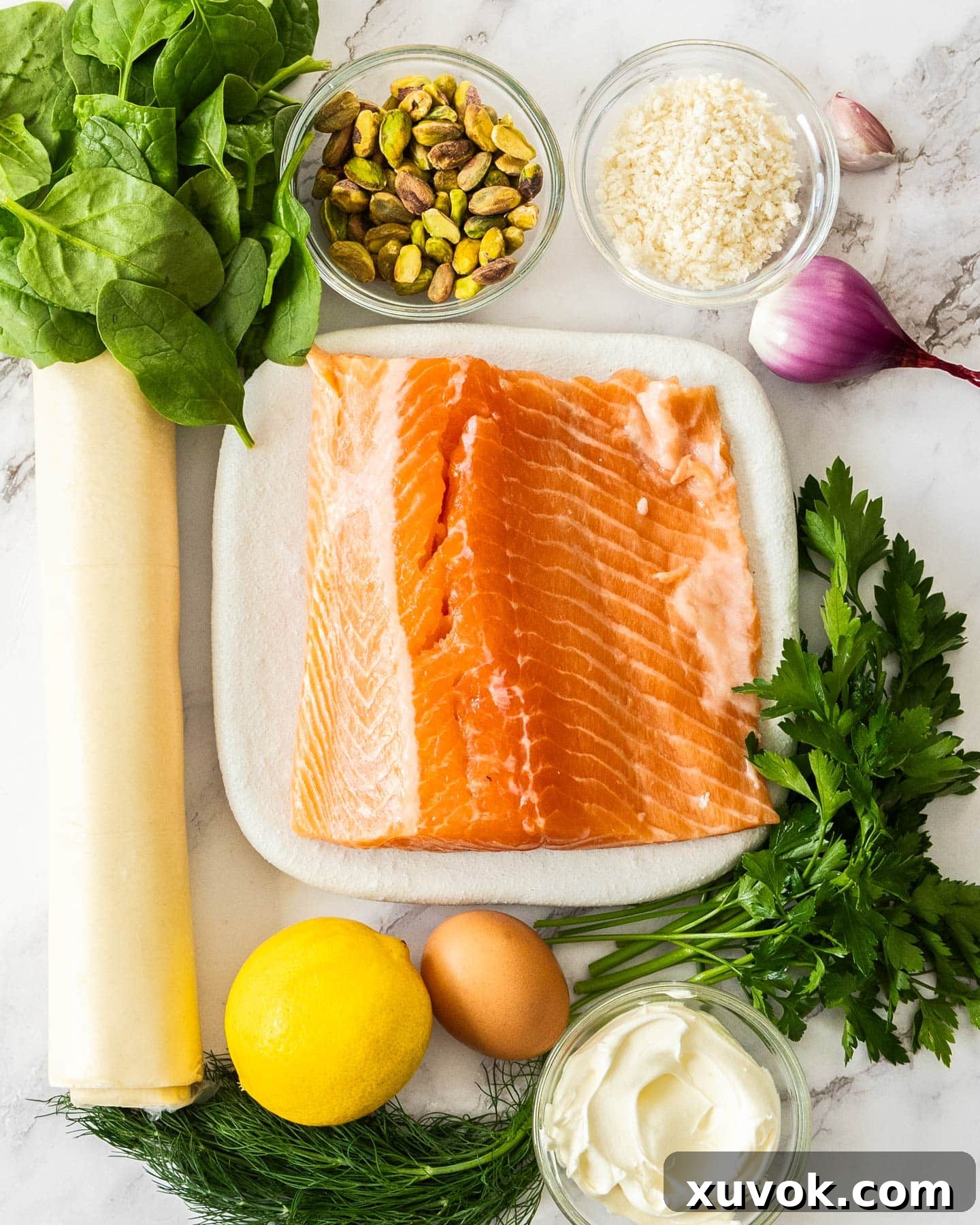 Ingredients for salmon wellington laid out on a wooden surface.