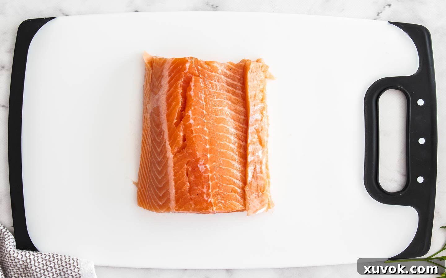 The salmon trim sitting on the thinnest part of the salmon piece, balancing the thickness.