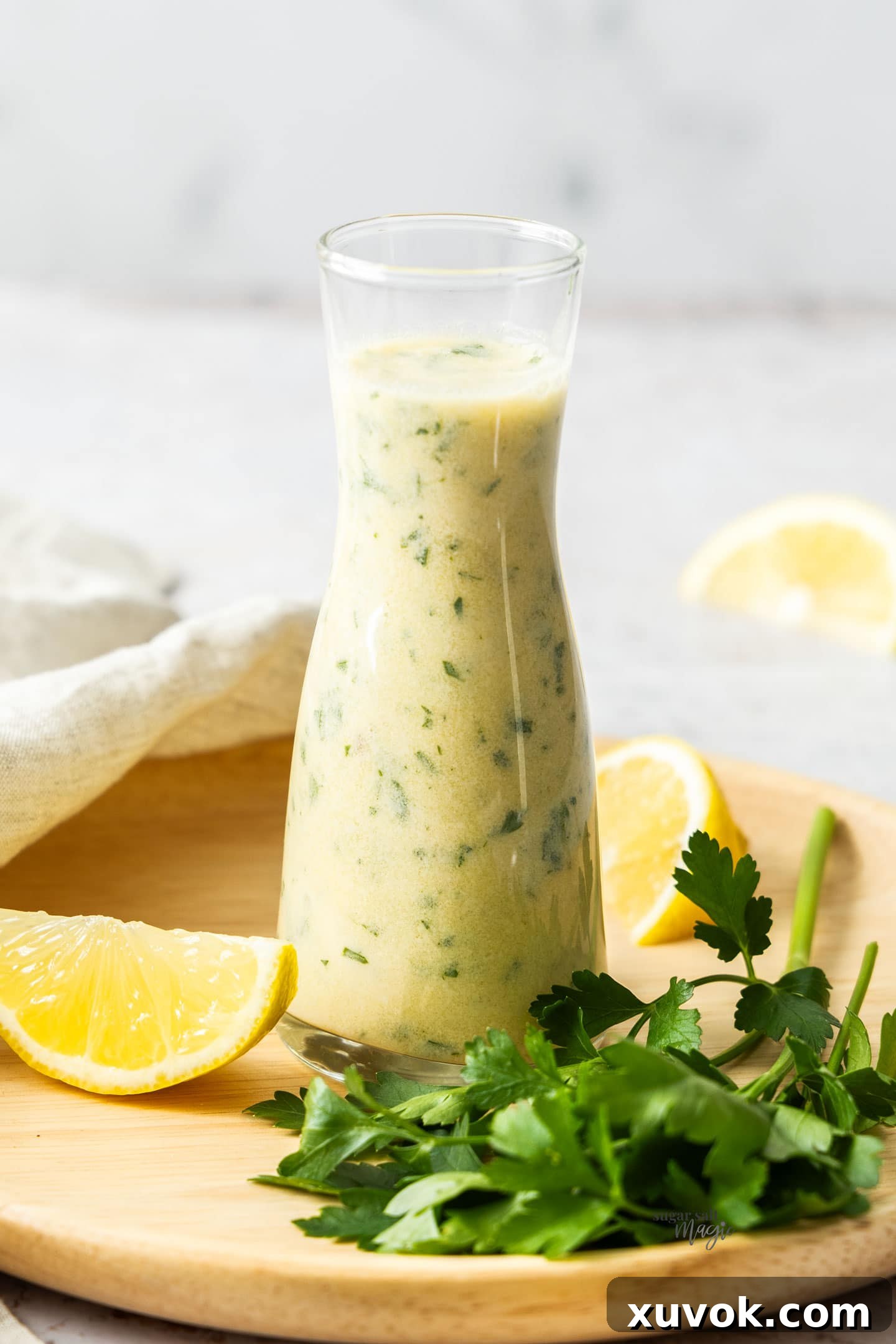 An elegant glass carafe containing a generous serving of the finished creamy white wine sauce, glistening and ready to elevate any meal.