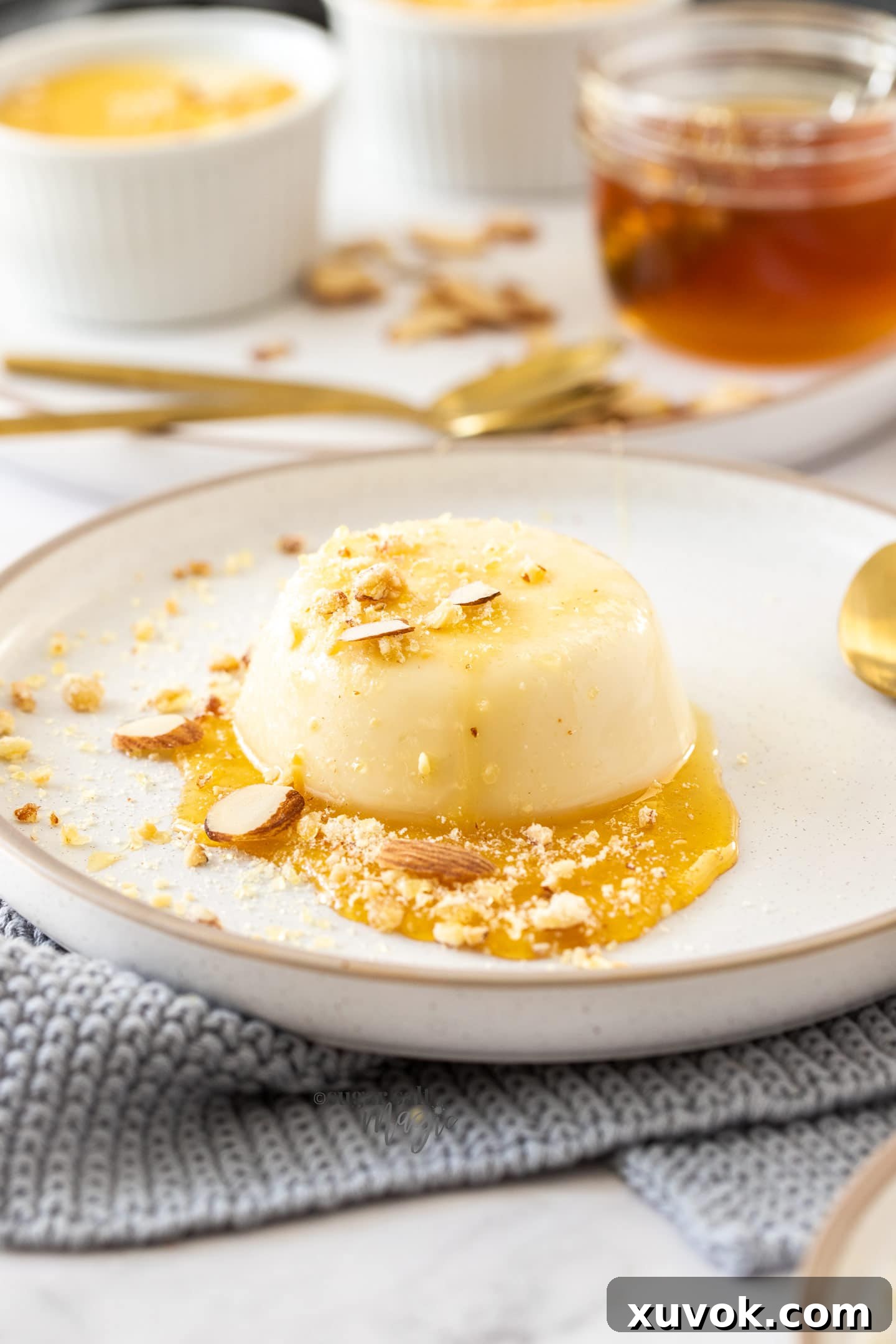 A beautifully presented honey panna cotta on a white plate, drizzled with extra honey.