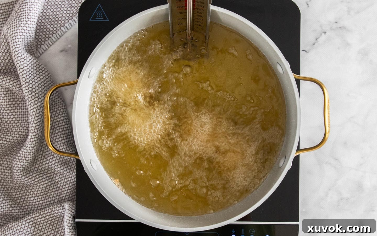 Several mushroom arancini balls sizzling and turning golden in hot deep-frying oil within a saucepan.