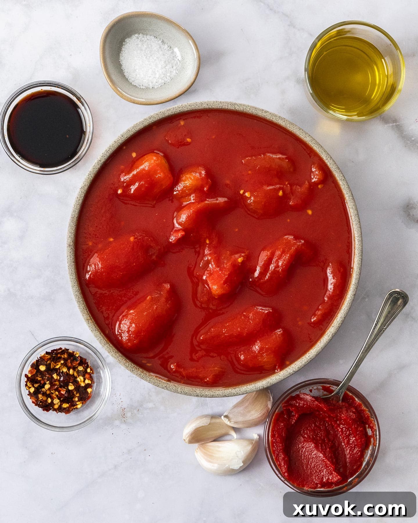 Fresh ingredients for homemade arrabbiata sauce laid out on a wooden board.