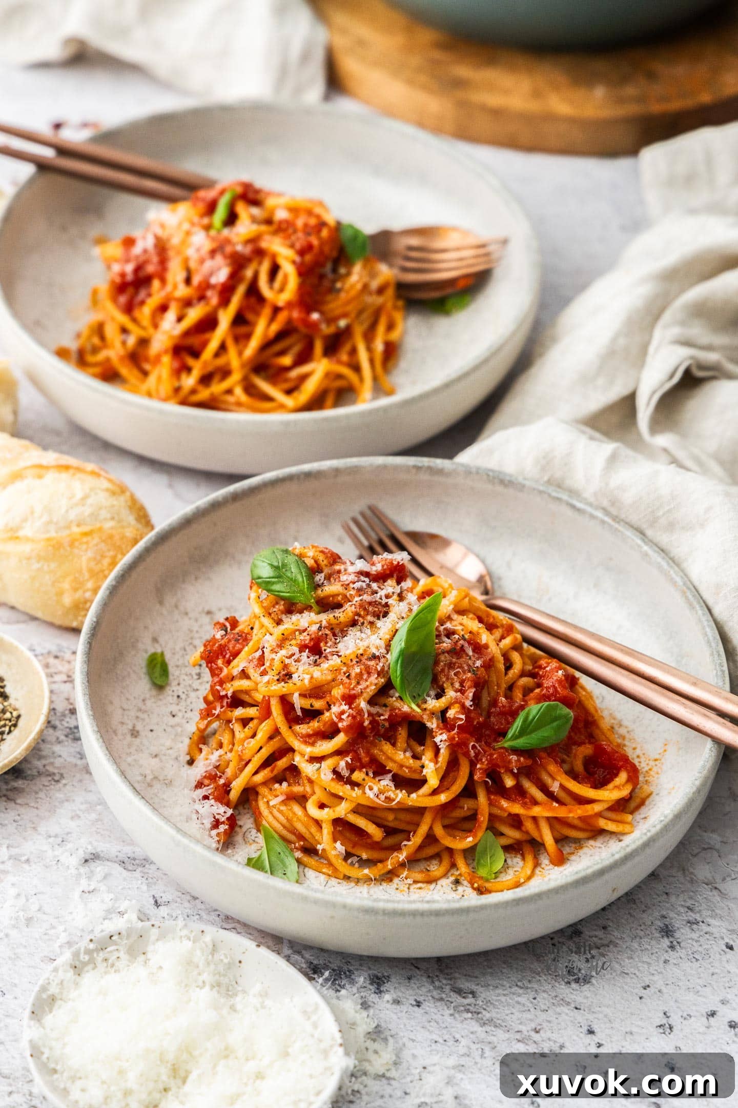 Two pasta bowls artfully arranged with generous servings of spaghetti arrabbiata, ready to be enjoyed.