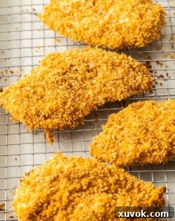 4 panko chicken schnitzels on a wire rack.