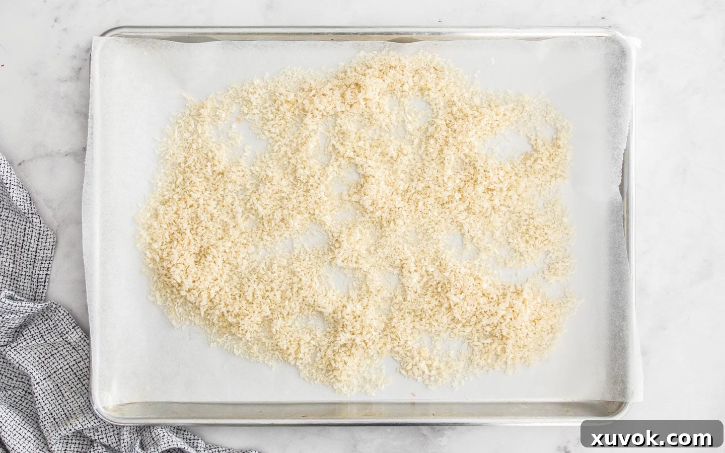 Panko bread crumbs on a baking tray before baking, light and white.