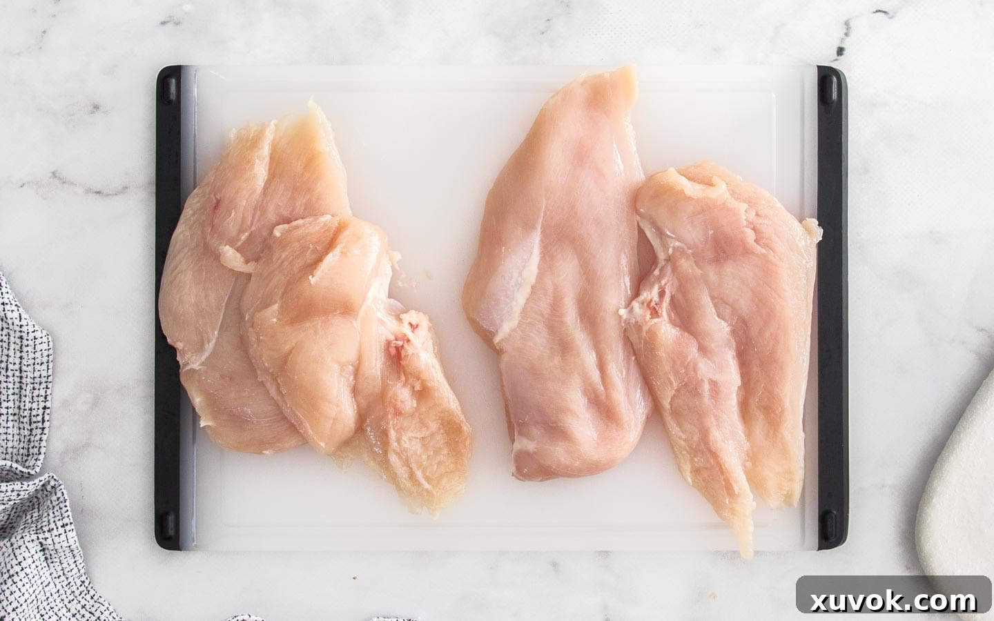 Chicken breasts sliced in half horizontally, ready for breading.