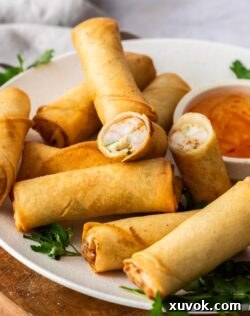 One spring roll cut in half to show the juicy prawn filling inside.